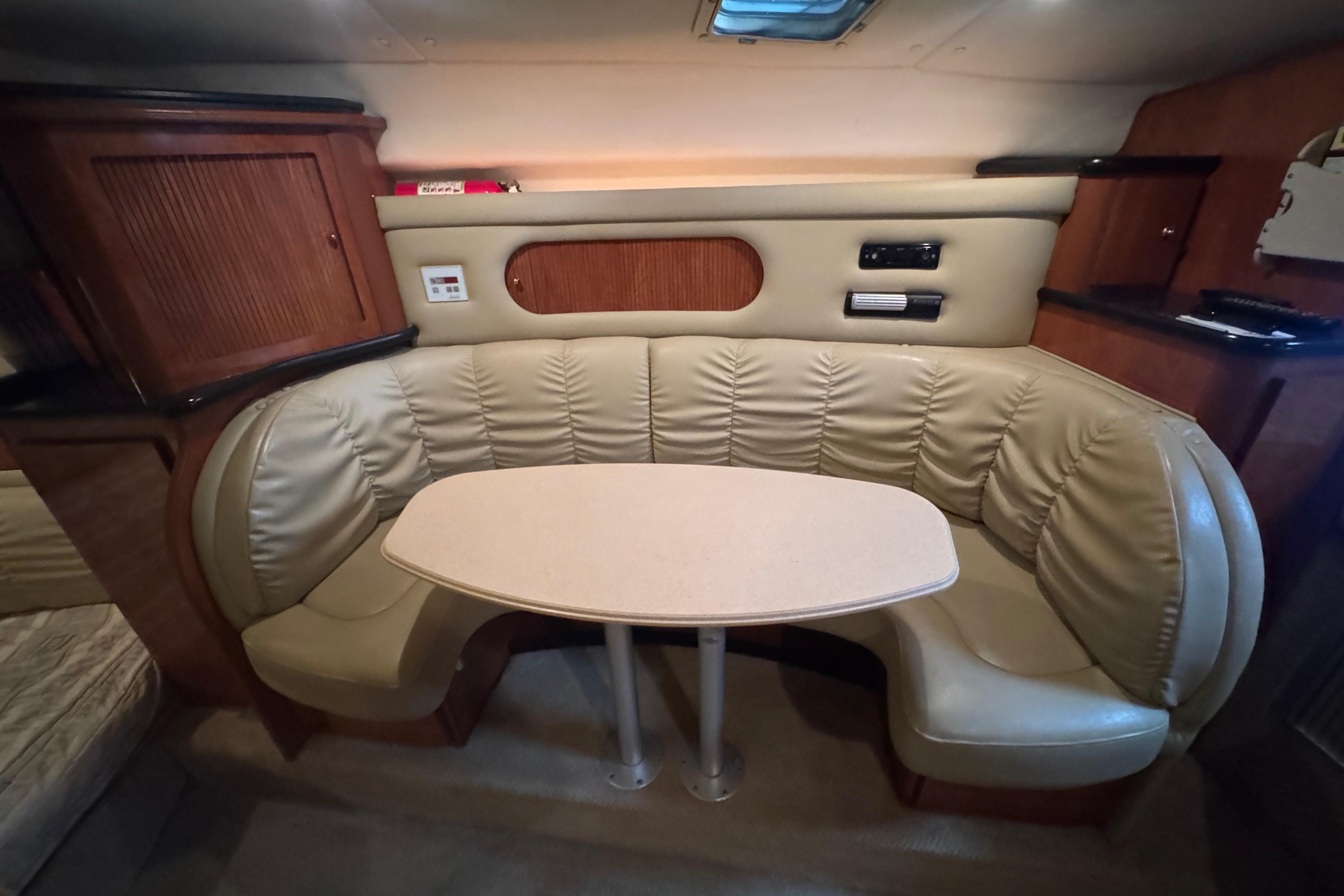 2004 Rinker Fiesta Vee 312 interior with beige leather seating and wooden cabinetry.