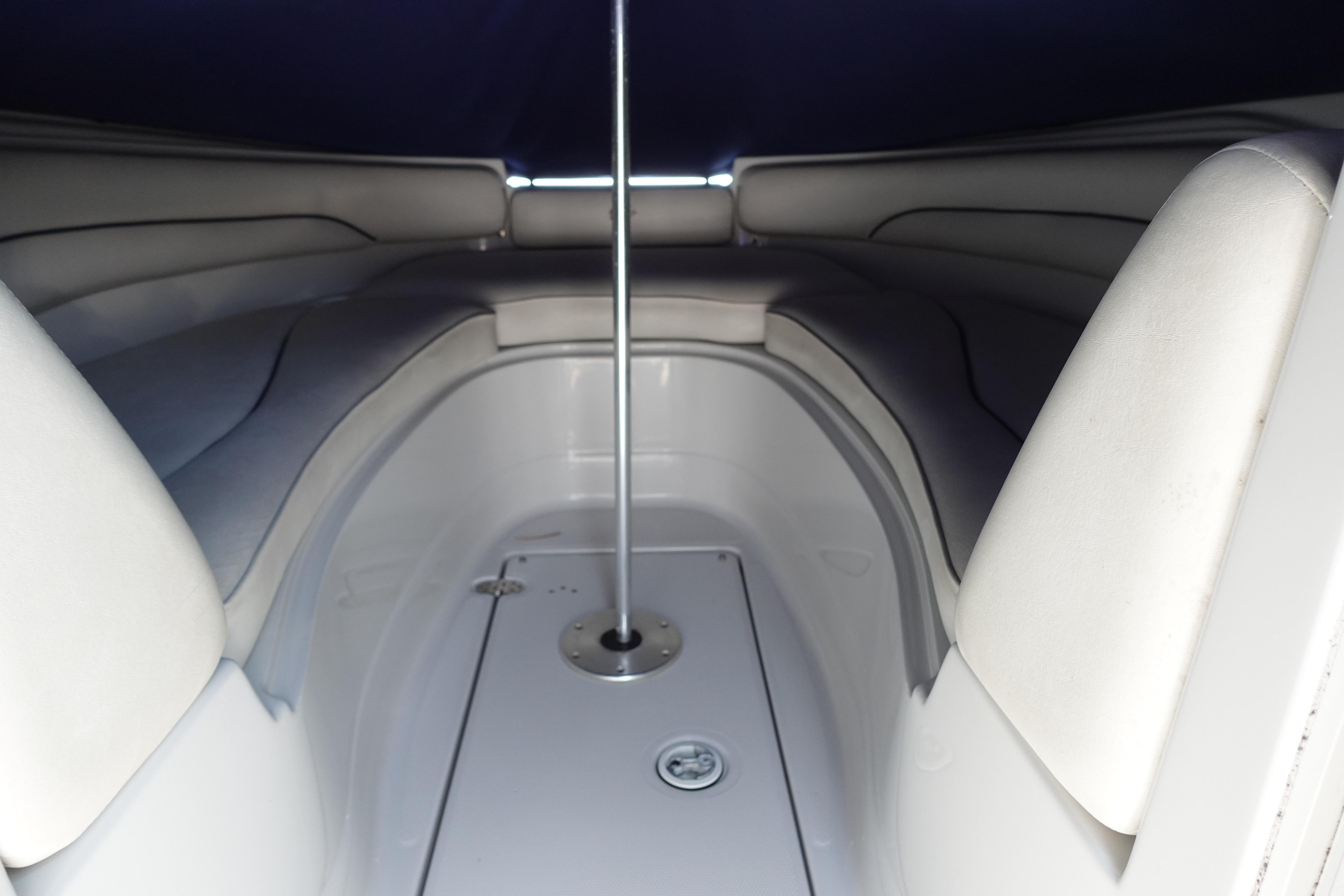 Interior view of a 2004 Crownline 240 EX boat, featuring cushioned seating and a central pole.