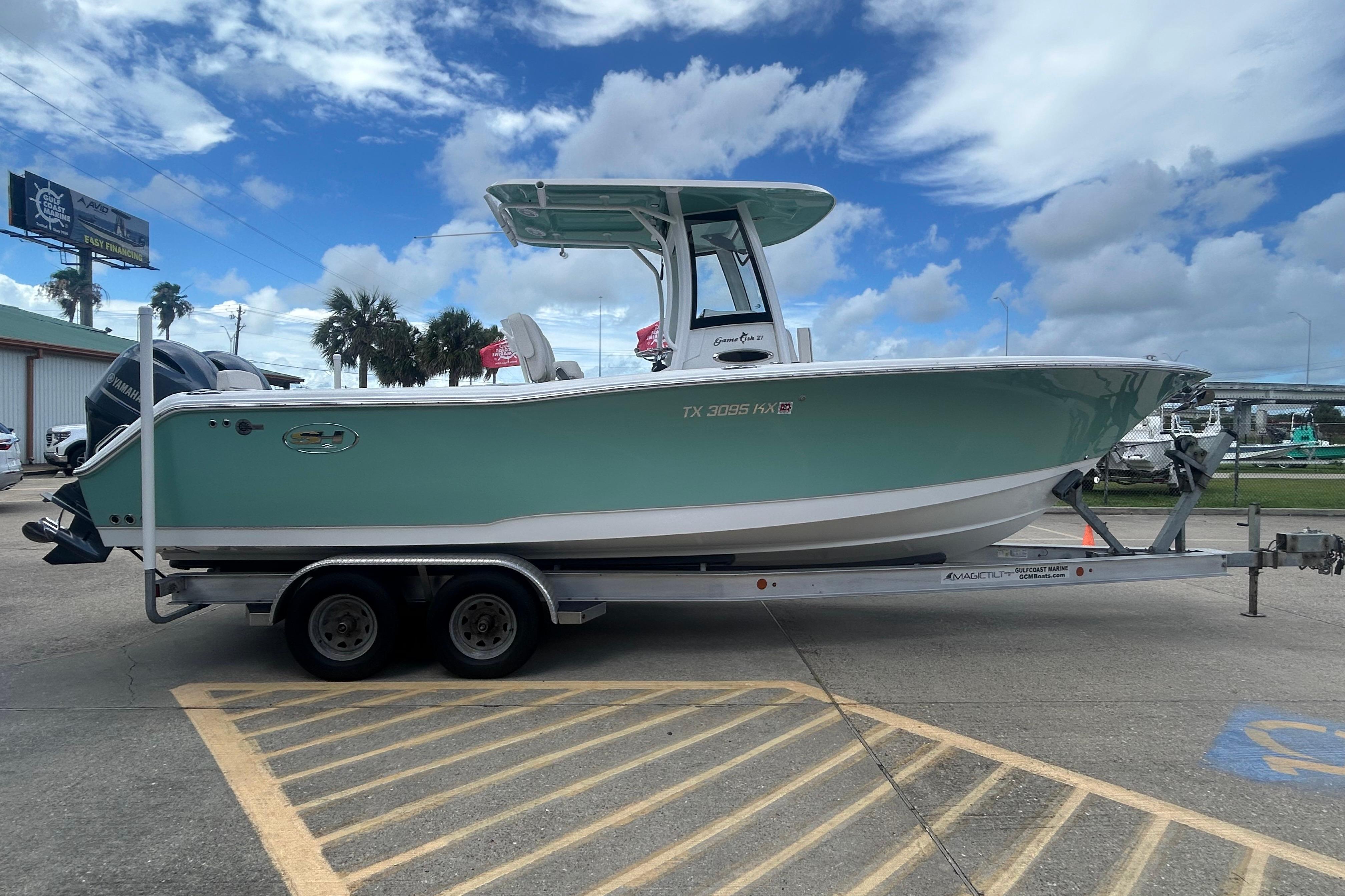 2023 Sea Hunt Gamefish 27 Coffin Box boat on trailer, parked outdoors under a cloudy sky.
