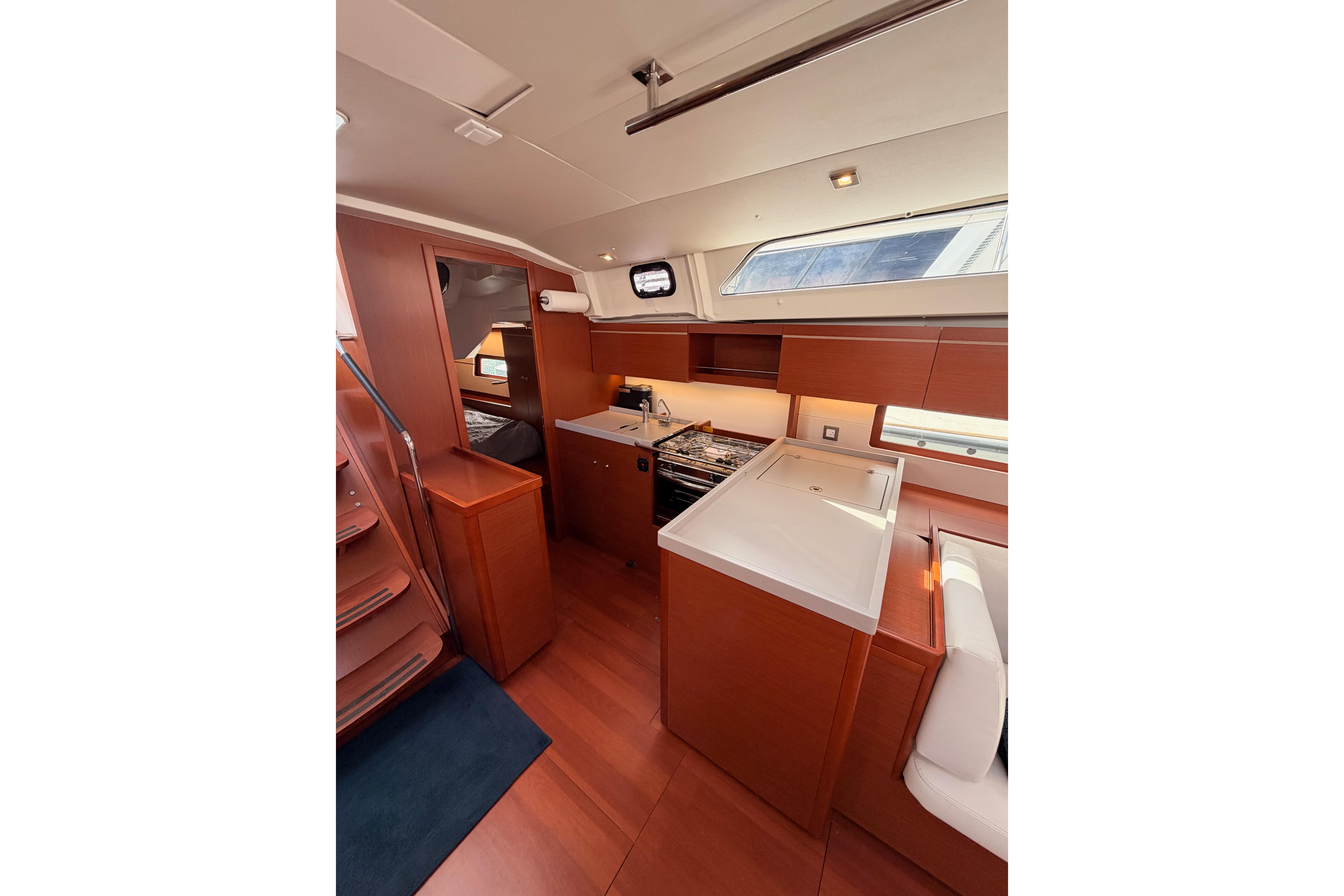 Interior of 2020 Beneteau Oceanis 46.1 yacht, featuring modern kitchen and wooden cabinetry.