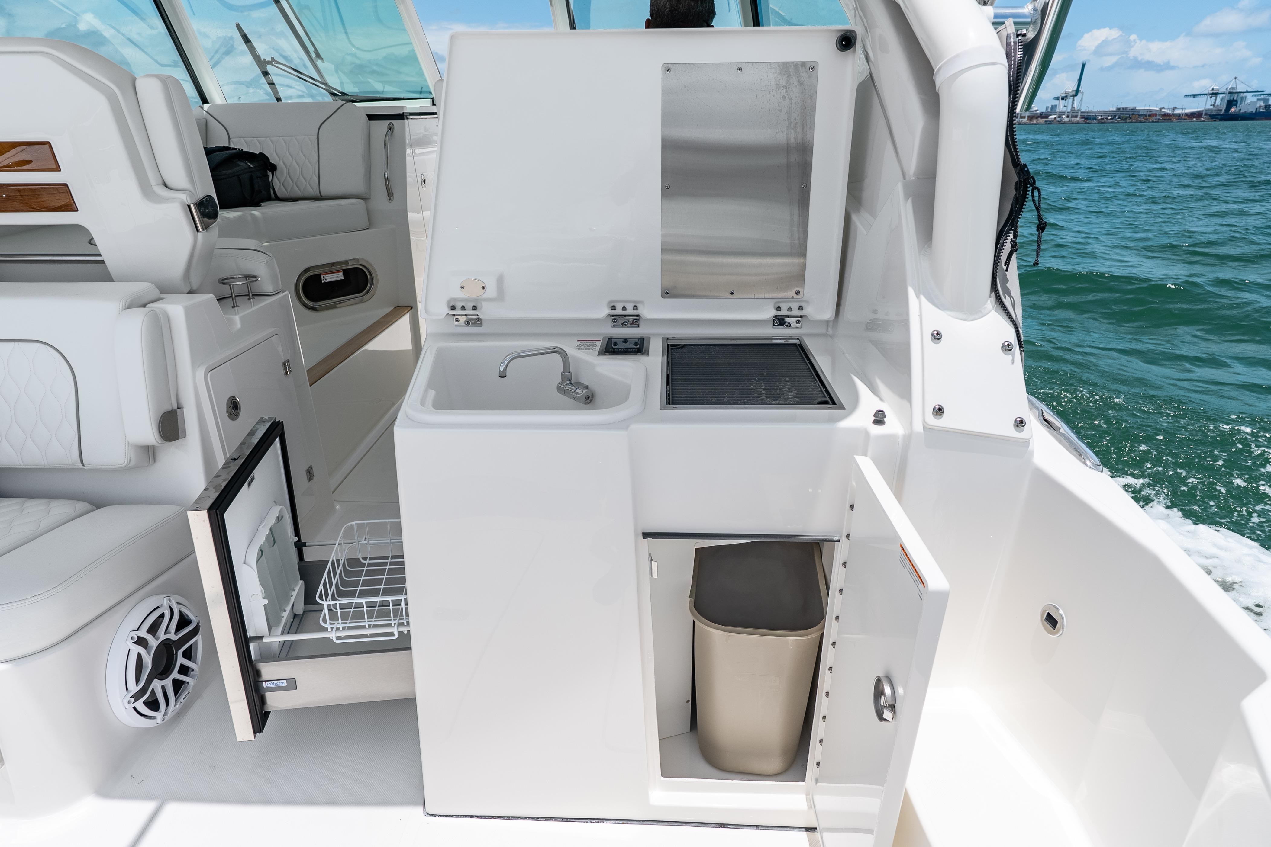 2026 Pursuit DC 326 Dual Console boat interior with sink and storage compartments.