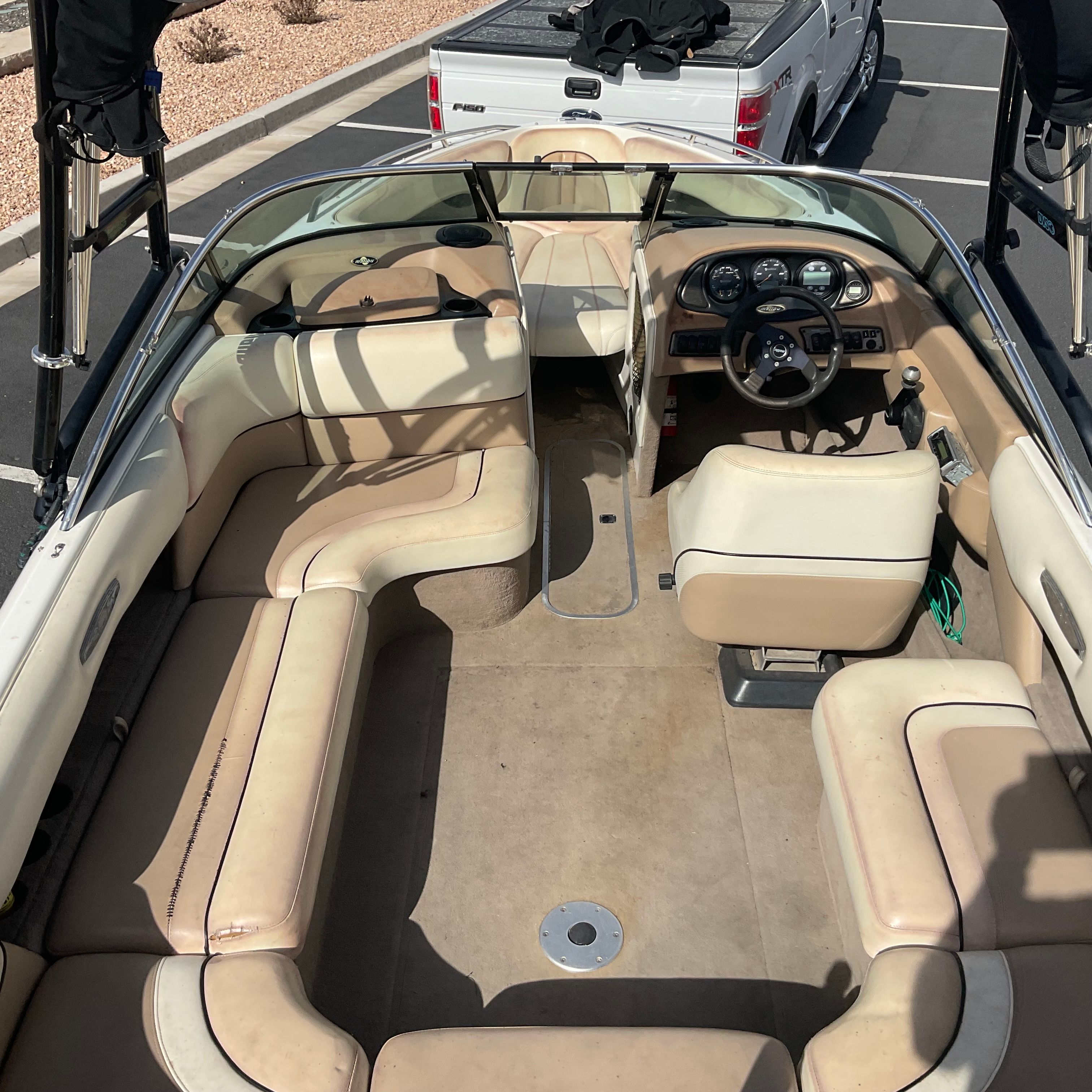 Interior view of a 2003 Malibu Wakesetter 23 LSV with beige seating and steering wheel.
