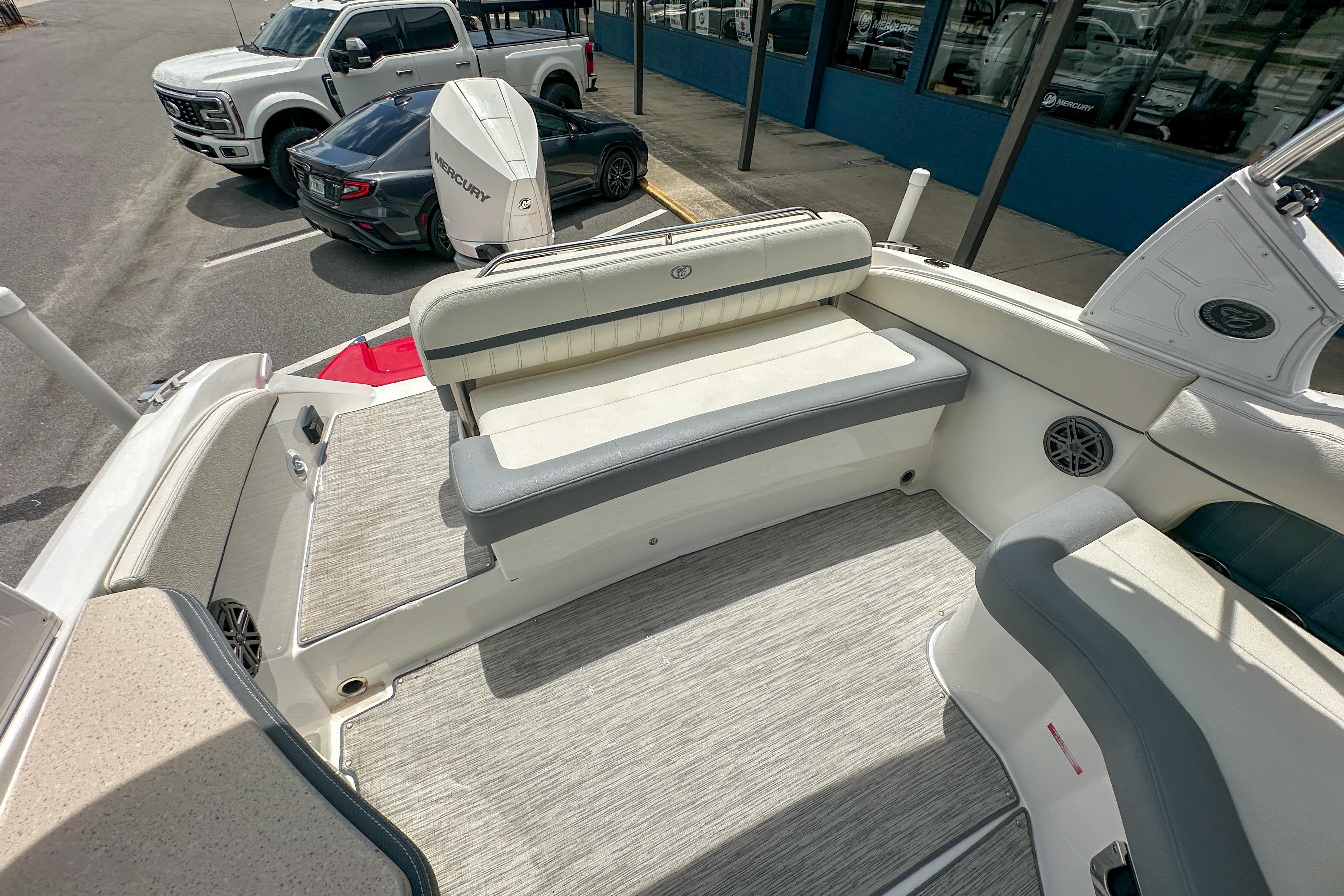 2022 Cobalt 25SC boat interior with seating, parked near vehicles.