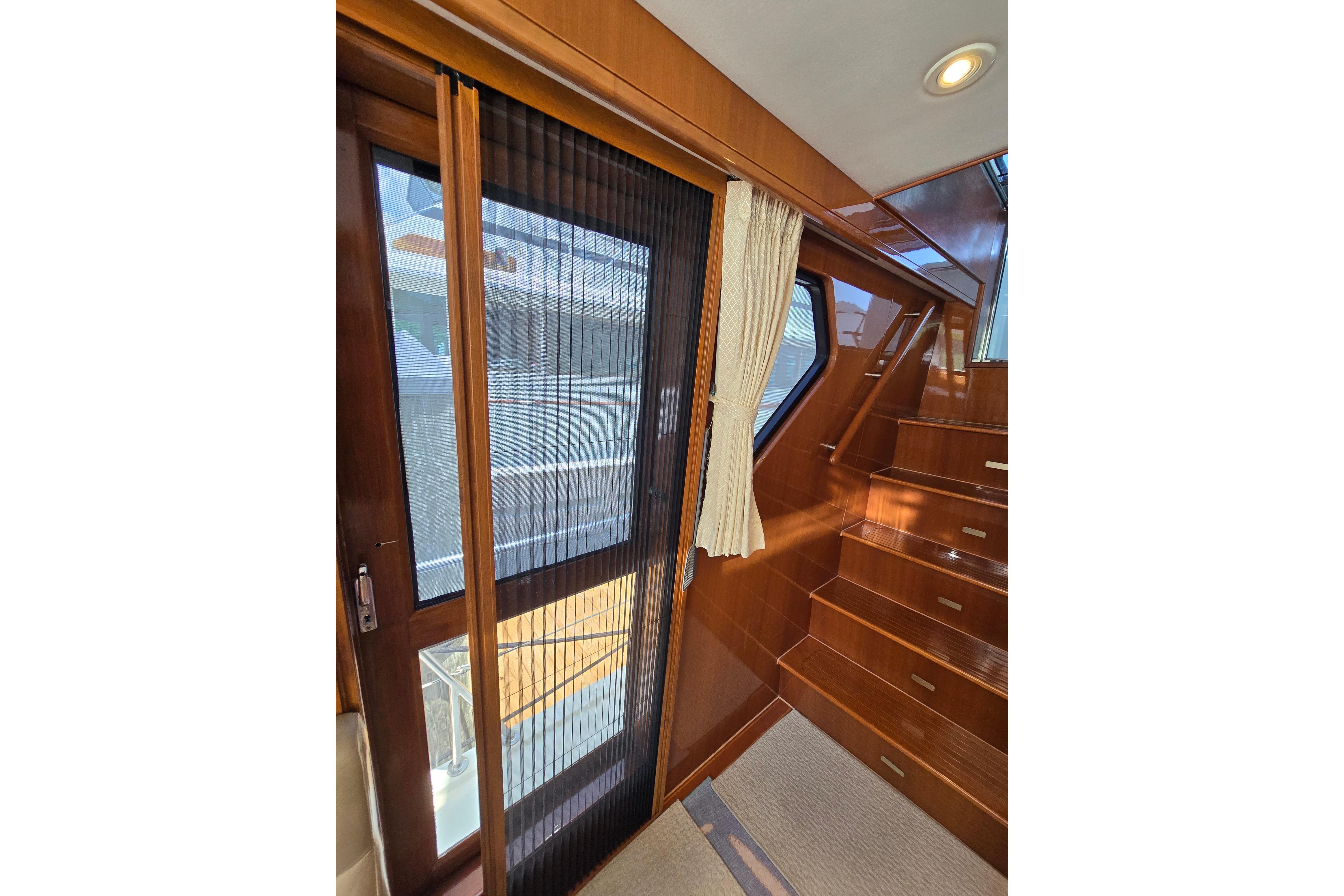 Interior of 2004 Grand Harbour 58 yacht with wooden stairs and sliding door.