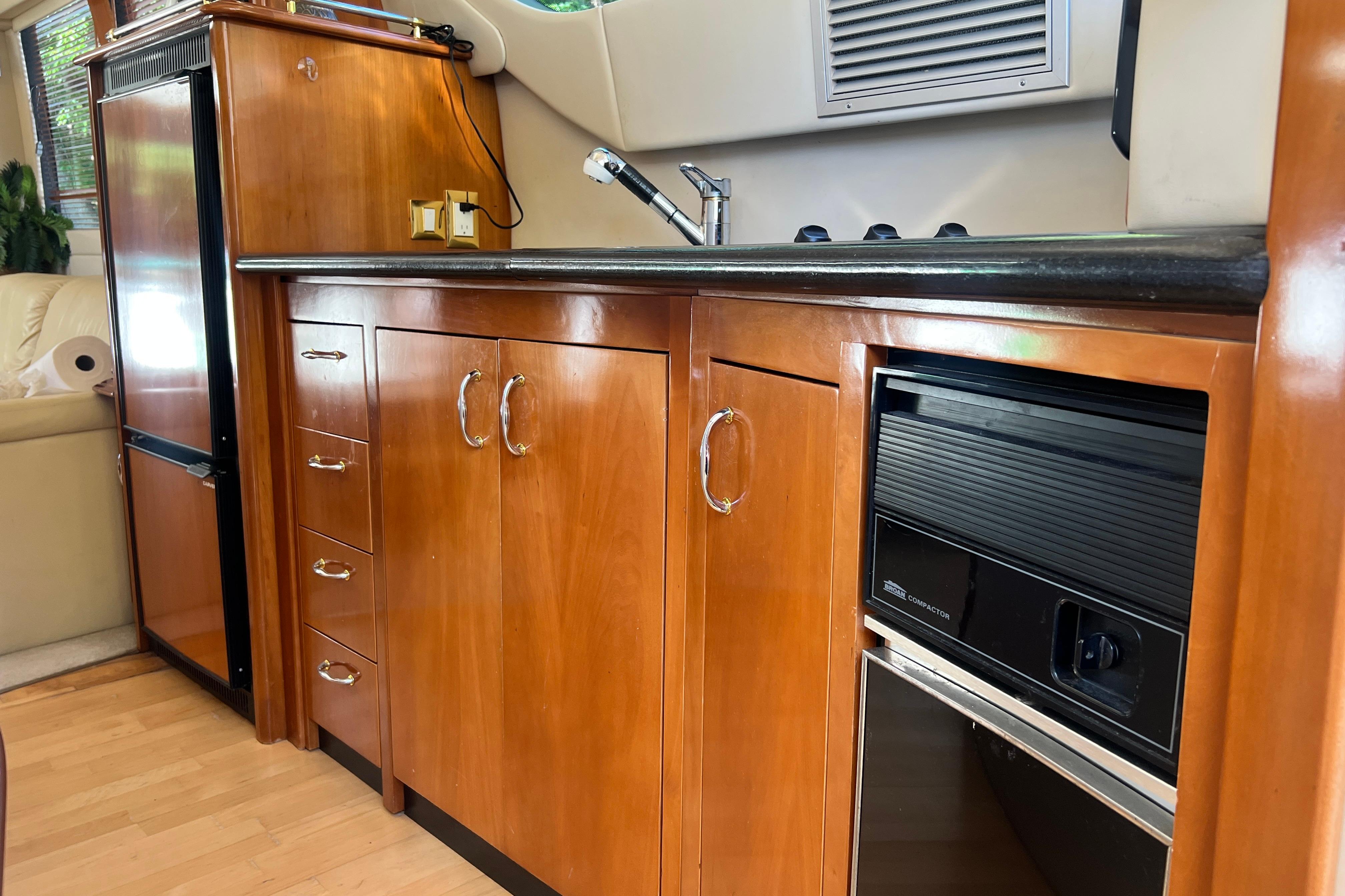 2003 Carver 450 Voyager Pilothouse kitchen with wood cabinetry and modern appliances.