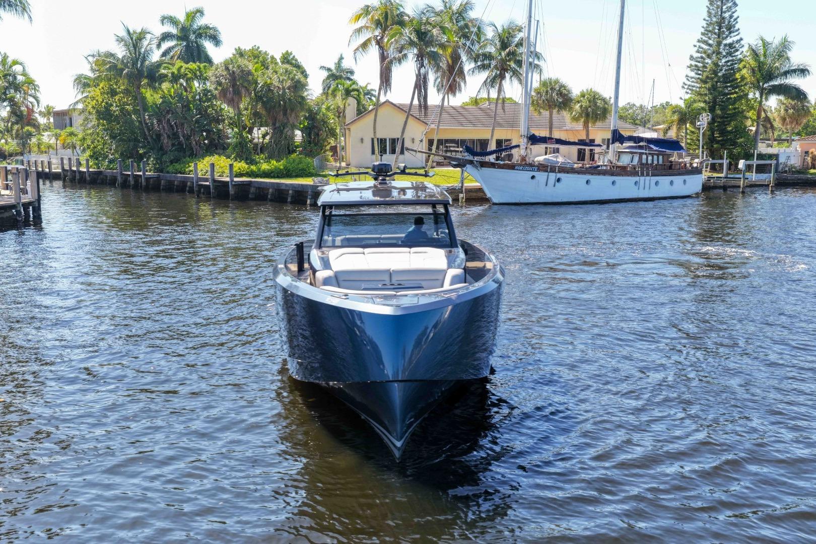 Vanquish Yachts VQ45 2022 model cruising on a scenic waterway with palm trees.