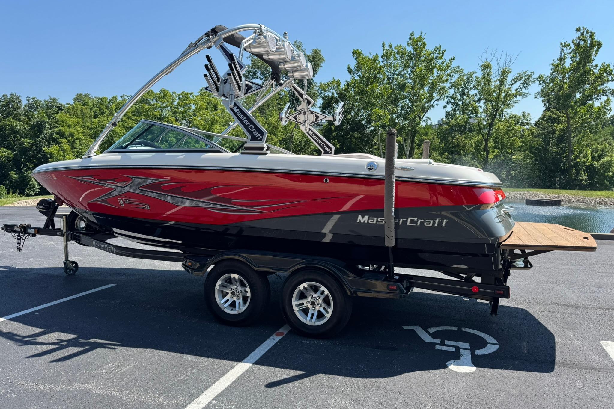 2007 MasterCraft X15 boat on trailer, red and black design, parked outdoors.