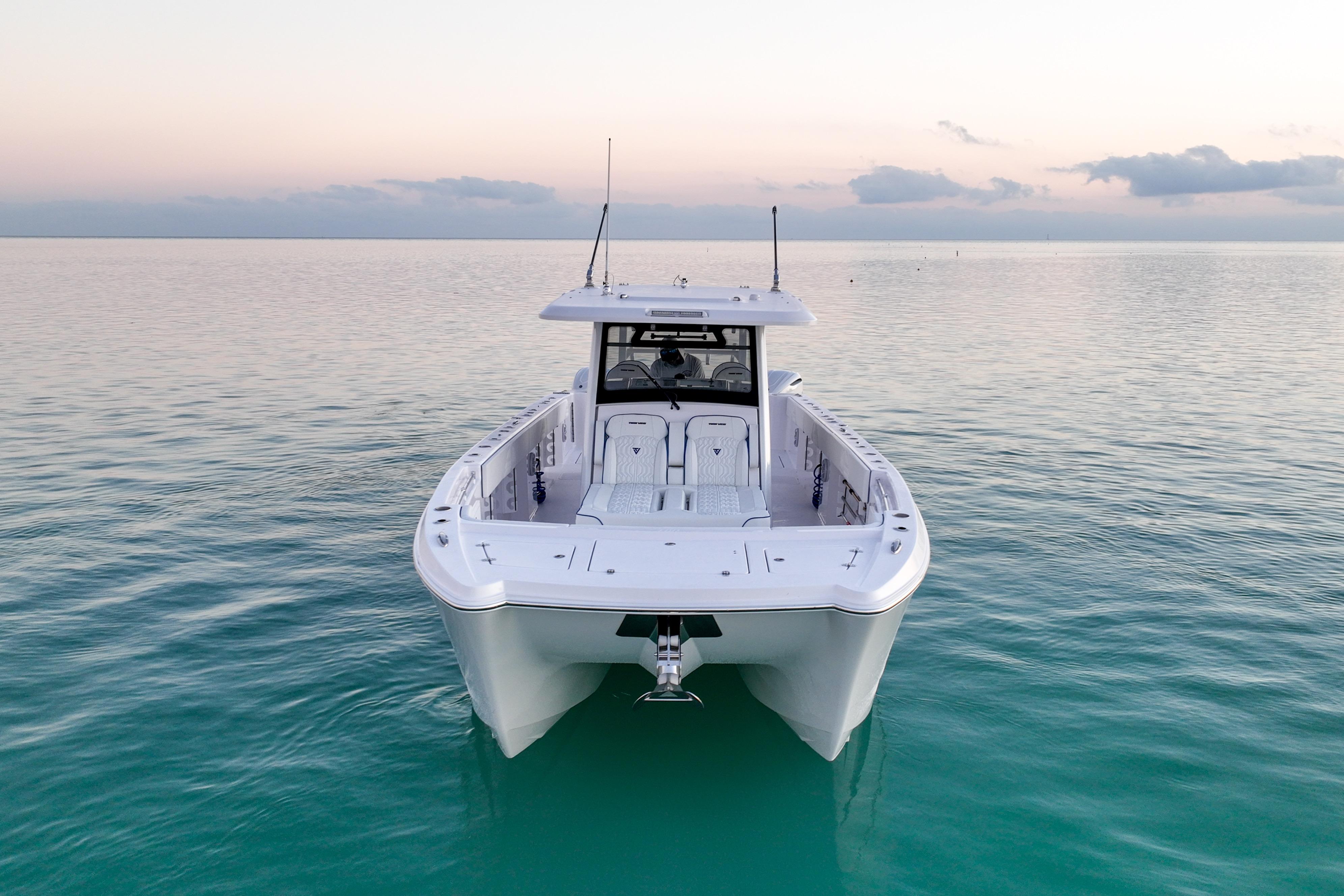 2026 Twin Vee 400 GFX2 CC boat on calm ocean at sunset.