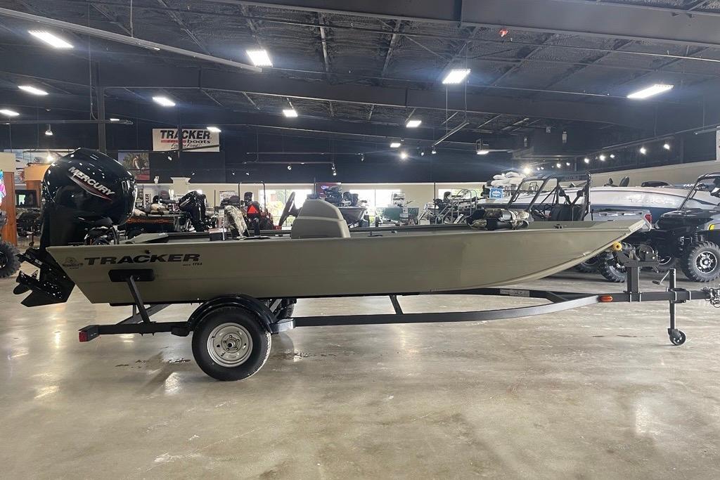 2026 Tracker Grizzly 1754 SC boat on trailer in showroom, featuring Mercury outboard motor.