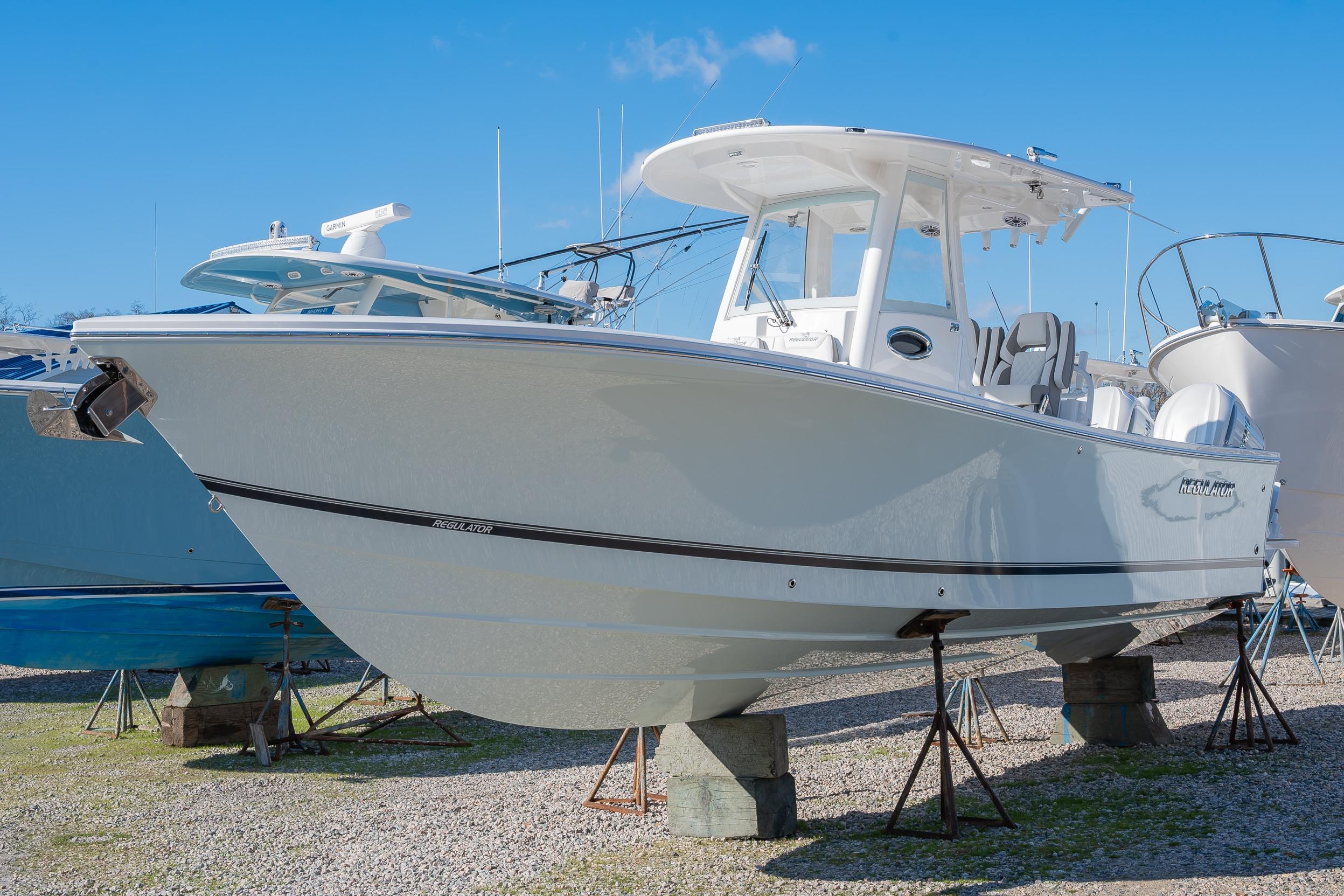 2026 Regulator 28 boat on display, elevated on stands, under clear blue sky.
