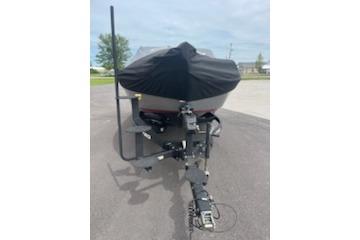 2023 Nitro ZV19 Sport boat with cover on trailer, parked outdoors.