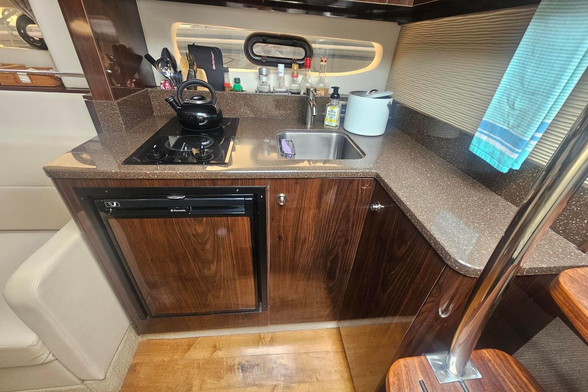 Luxurious 2016 Sea Ray Sundancer 350 yacht kitchen with sleek countertops and modern appliances.