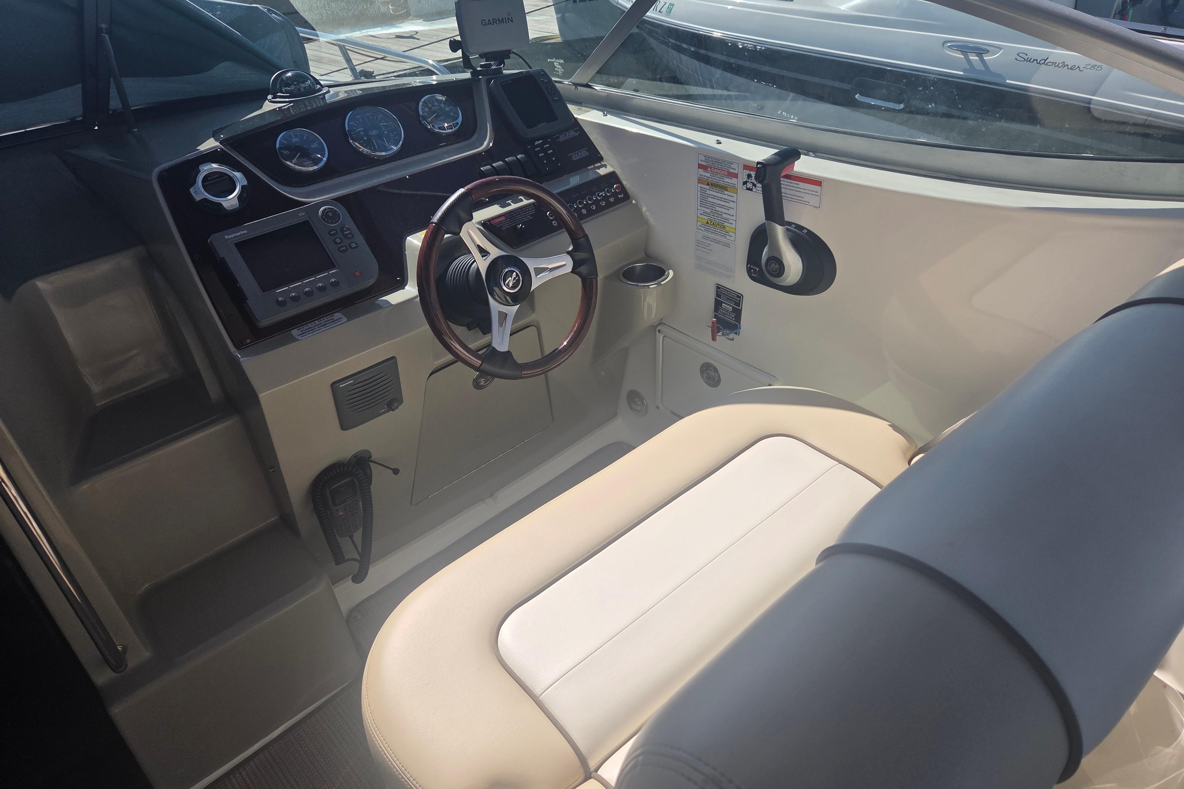 Interior cockpit of a 2012 Sea Ray Sundancer 260 boat, featuring steering wheel and controls.