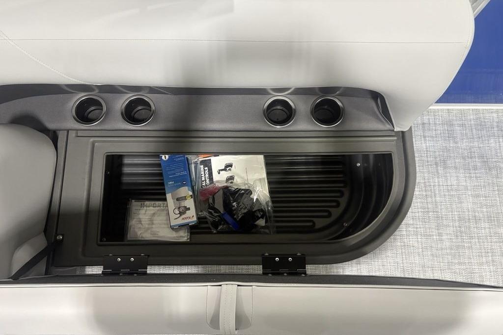 Storage compartment in 2026 Sun Tracker Party Barge 16 DLX with cup holders and accessories.