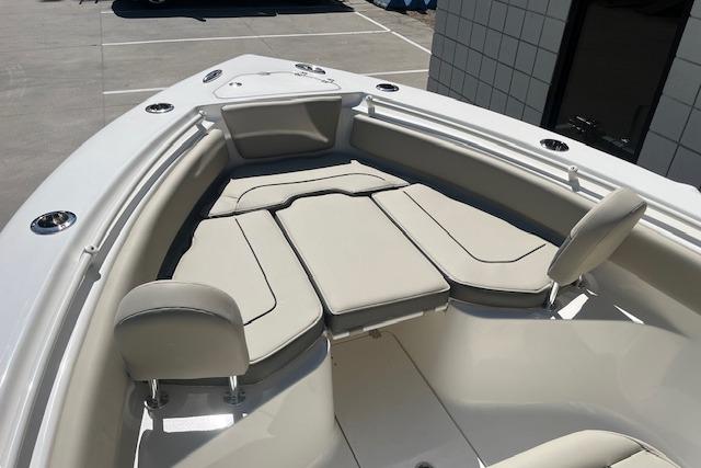 2026 Key West 239 FS boat interior with cushioned seating in a marina setting.