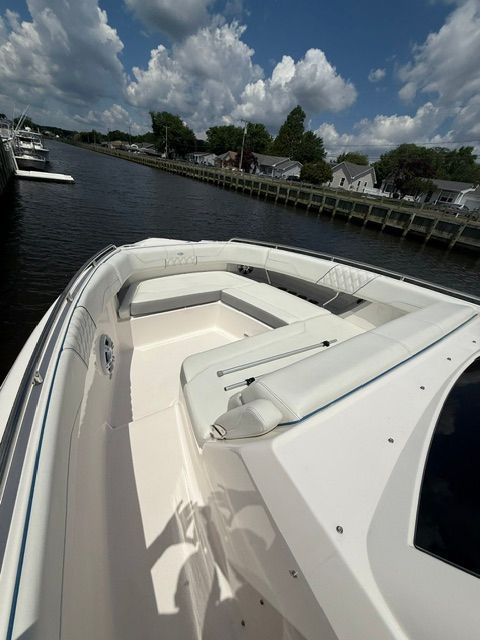2025 Regal 33 SAV with spacious white deck and seating area, docked by the water.
