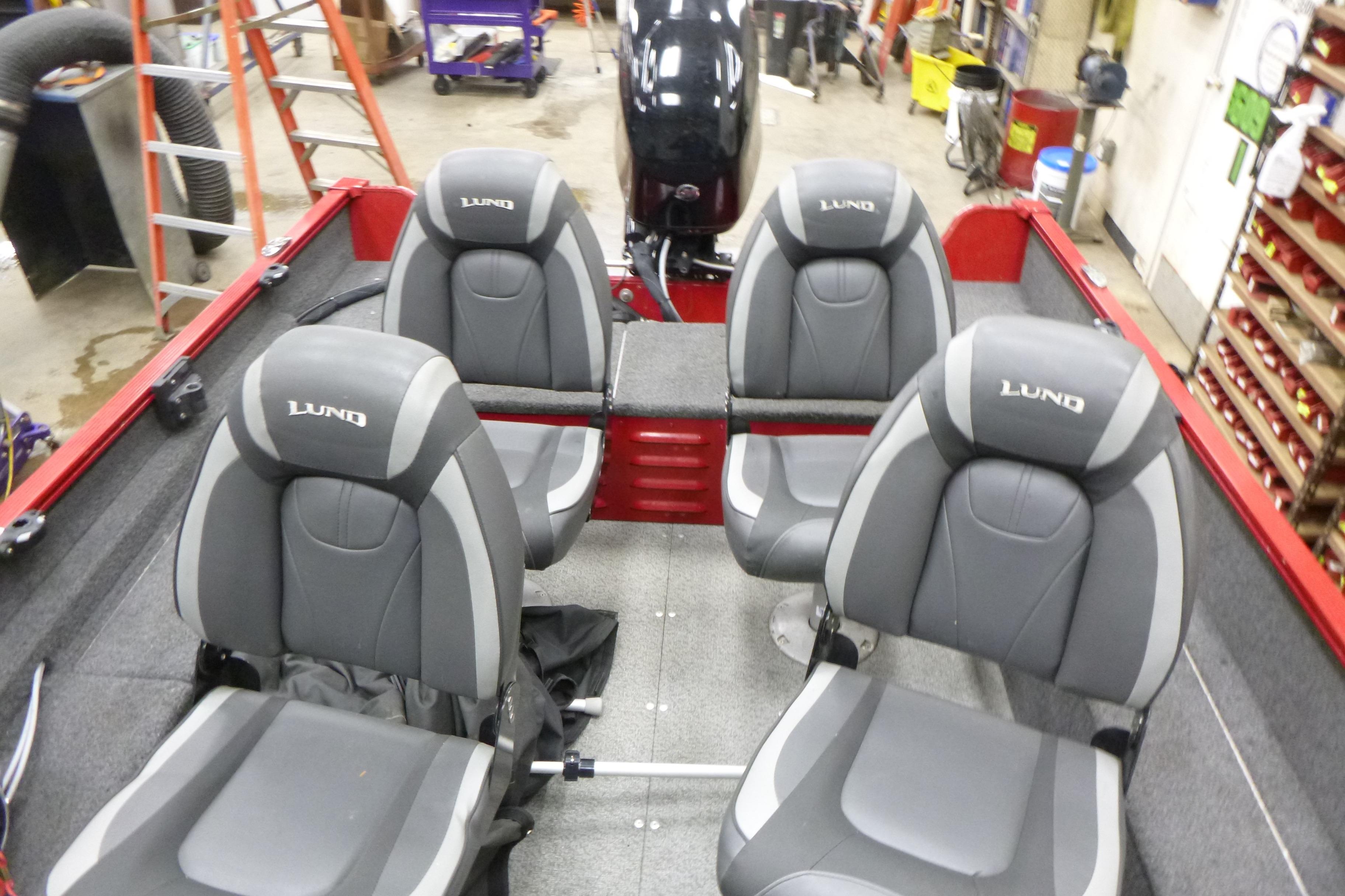 2022 Lund 1650 Angler Sport boat interior with four gray seats in a workshop.