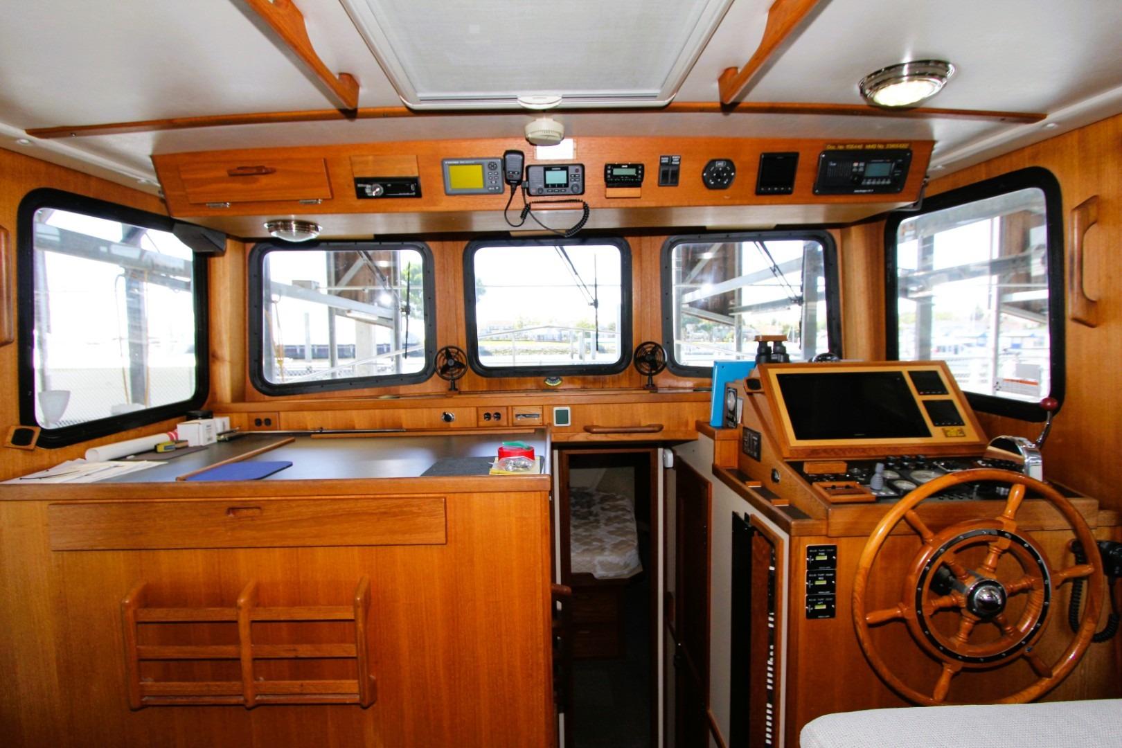 Interior of a 2002 Nordic Tug 37, featuring a wooden helm and navigation equipment.