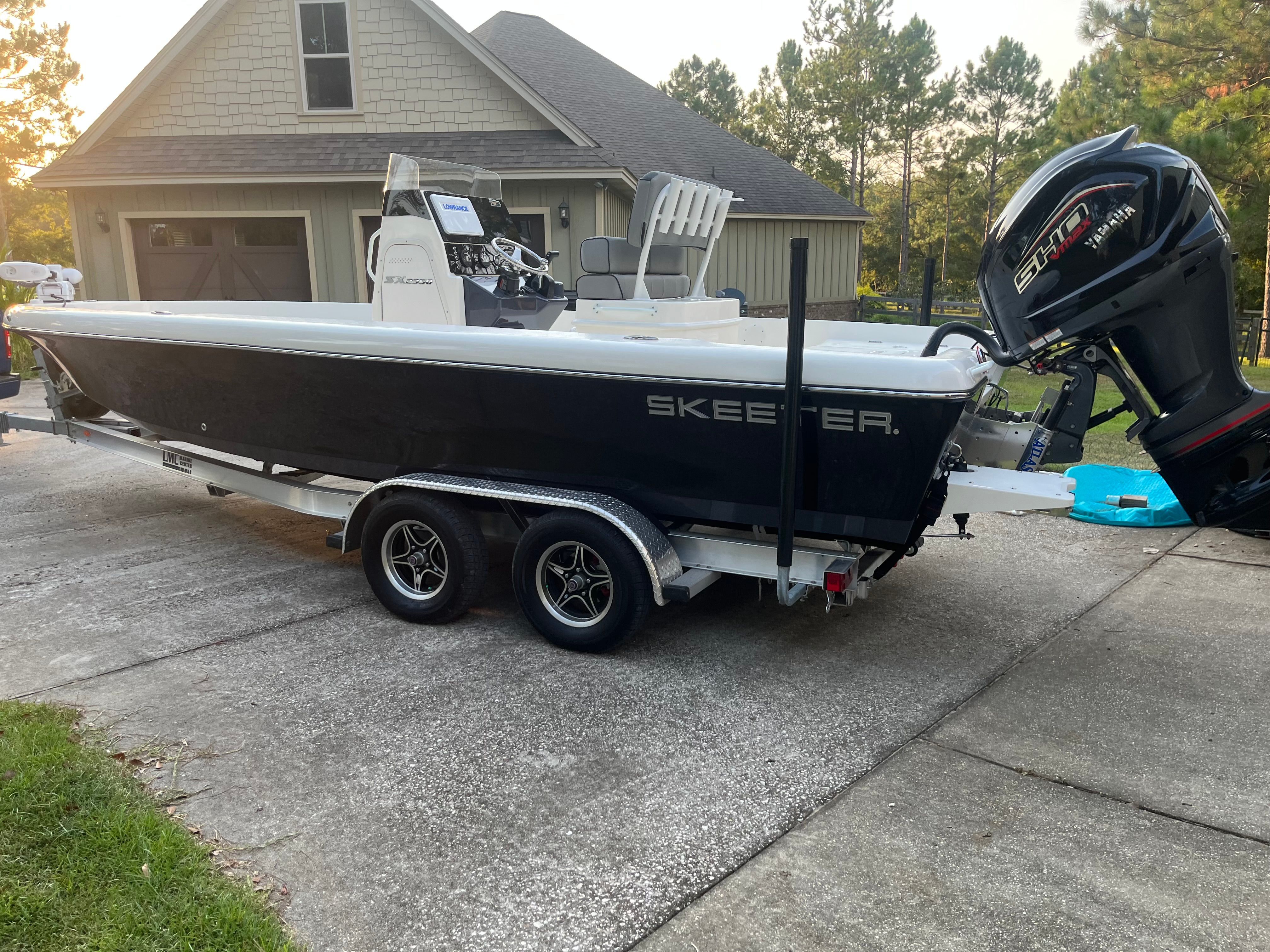 A 2023 Skeeter SX2350 boat on a trailer in front of a garage.