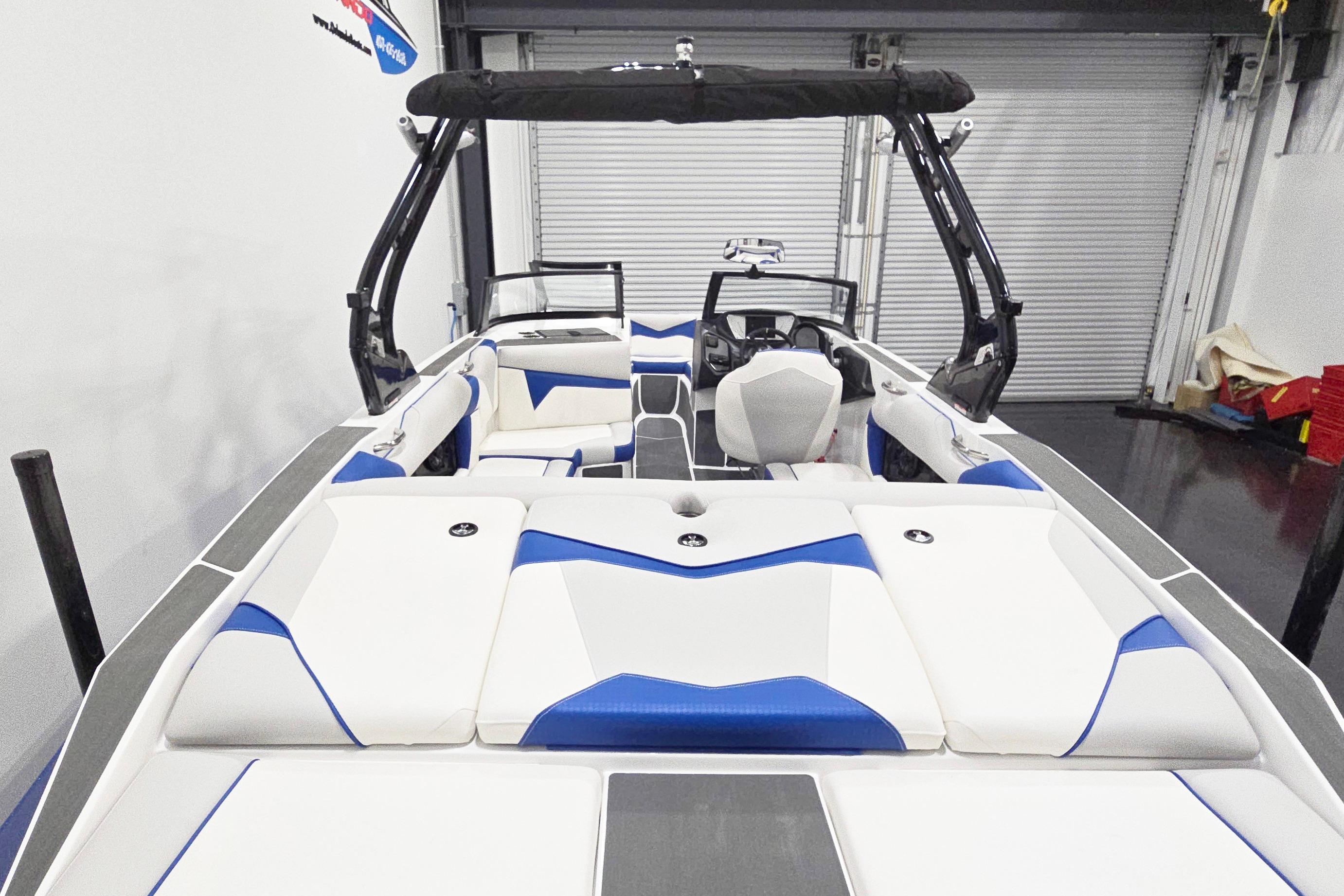 2026 Supreme S220 boat interior with white and blue seating, sleek design.