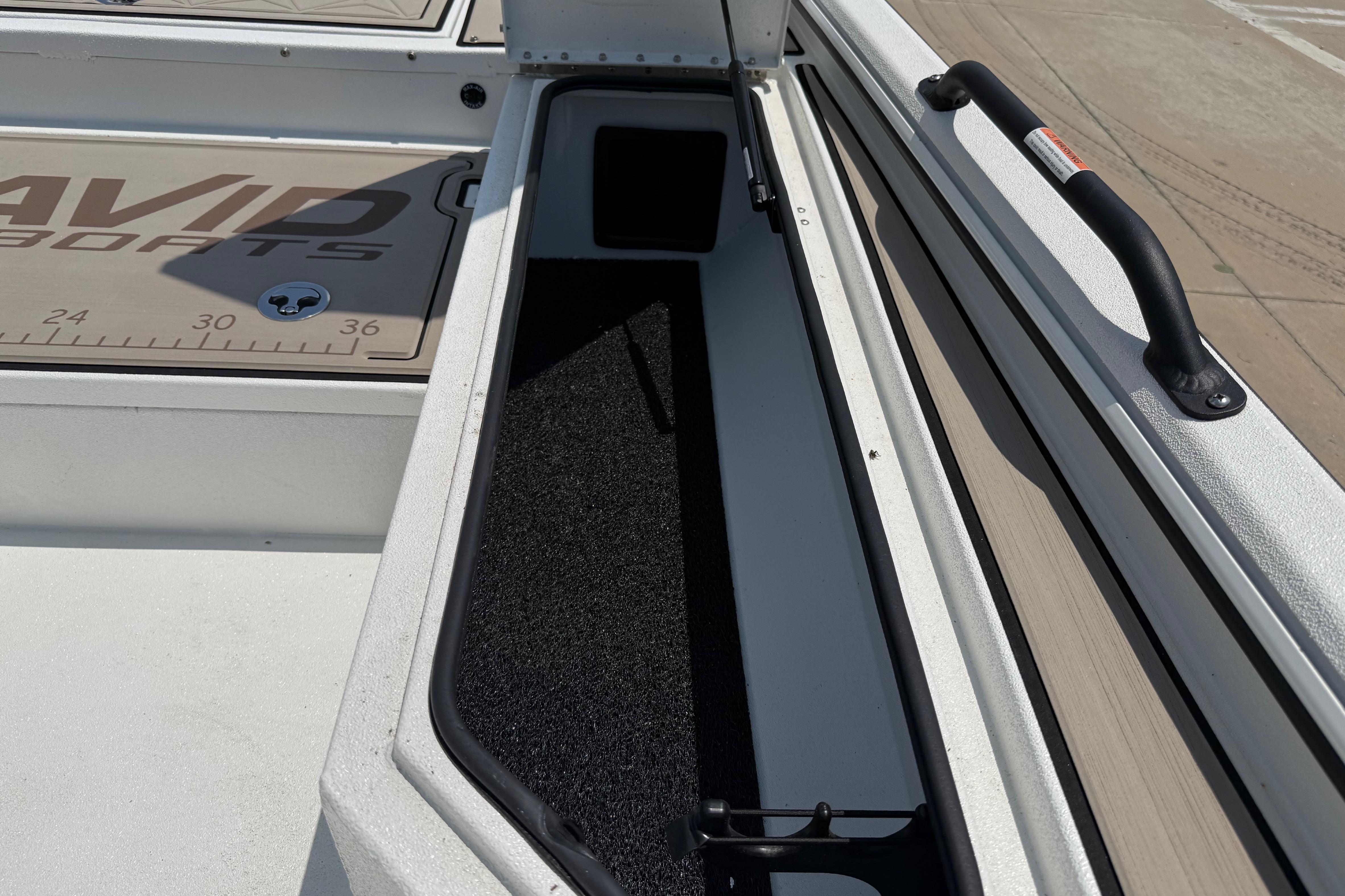 2025 Avid 22 Recon boat interior storage compartment with handle and measurement markings.