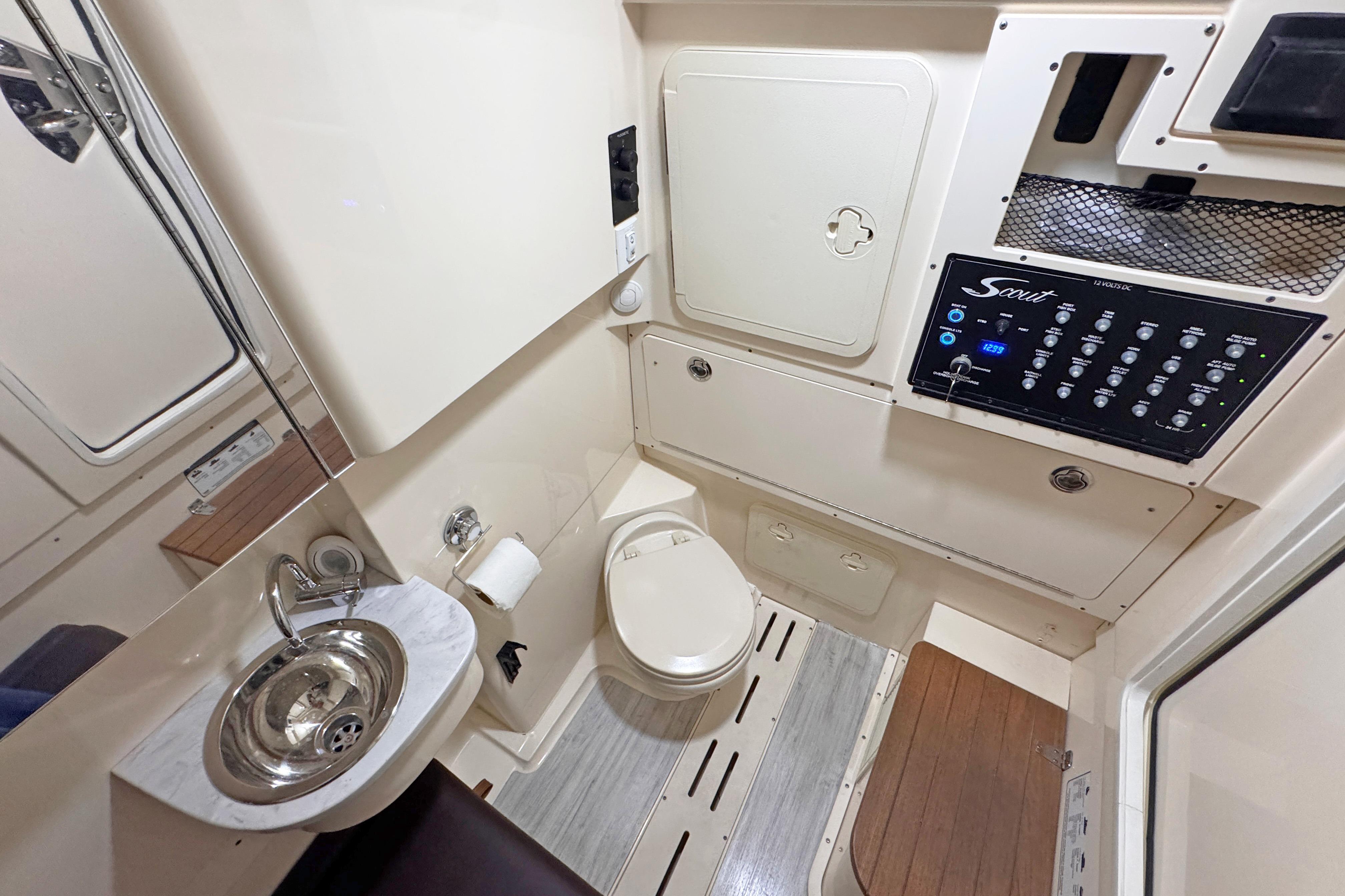 2021 Scout 305 LXF boat interior with compact bathroom and control panel.