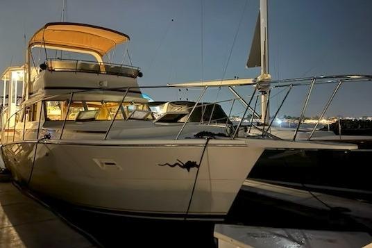 1980 Viking 43 Convertible yacht docked at night, illuminated by soft lighting.