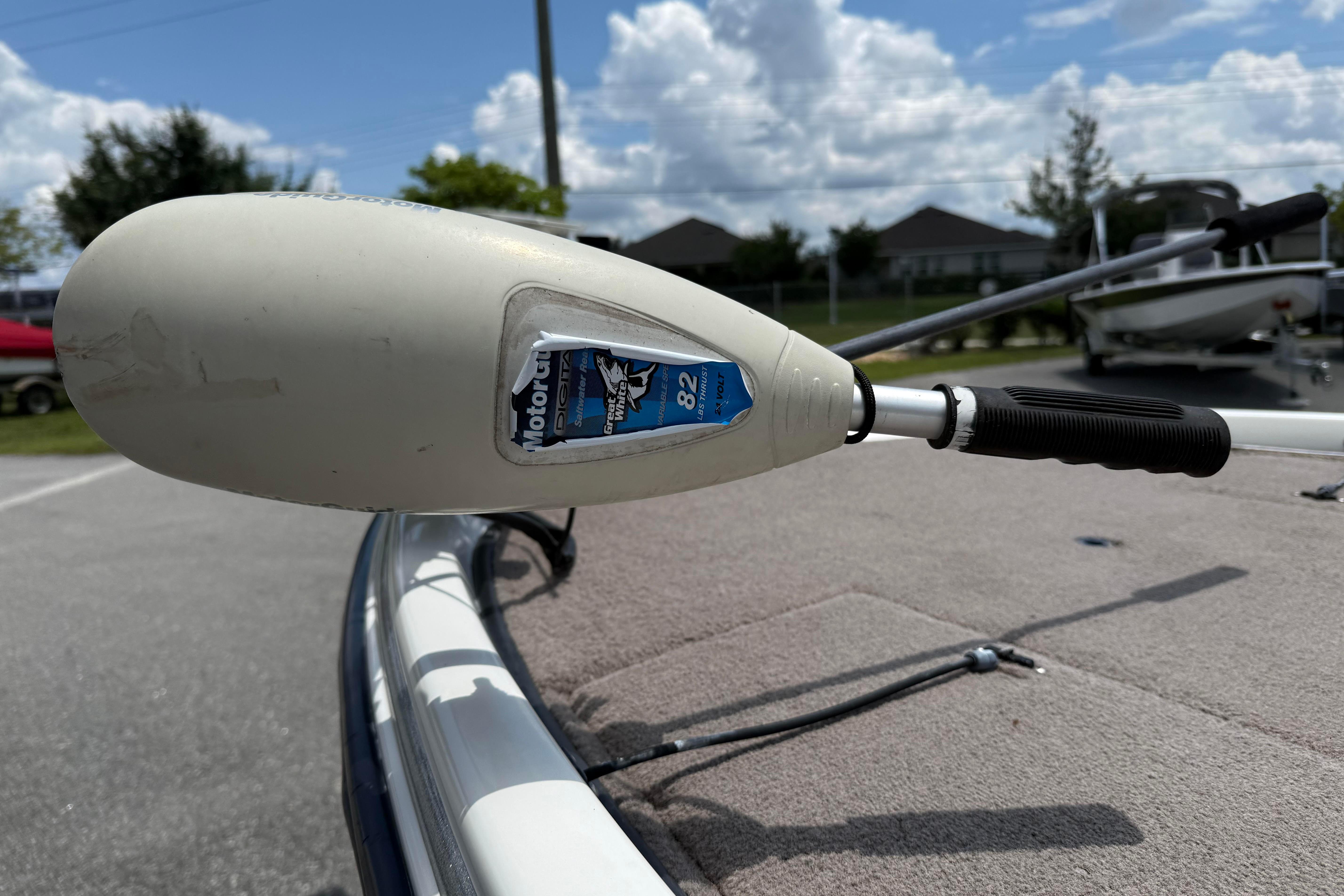2006 Stratos 294 Pro XL boat with MotorGuide trolling motor, parked outdoors under a cloudy sky.