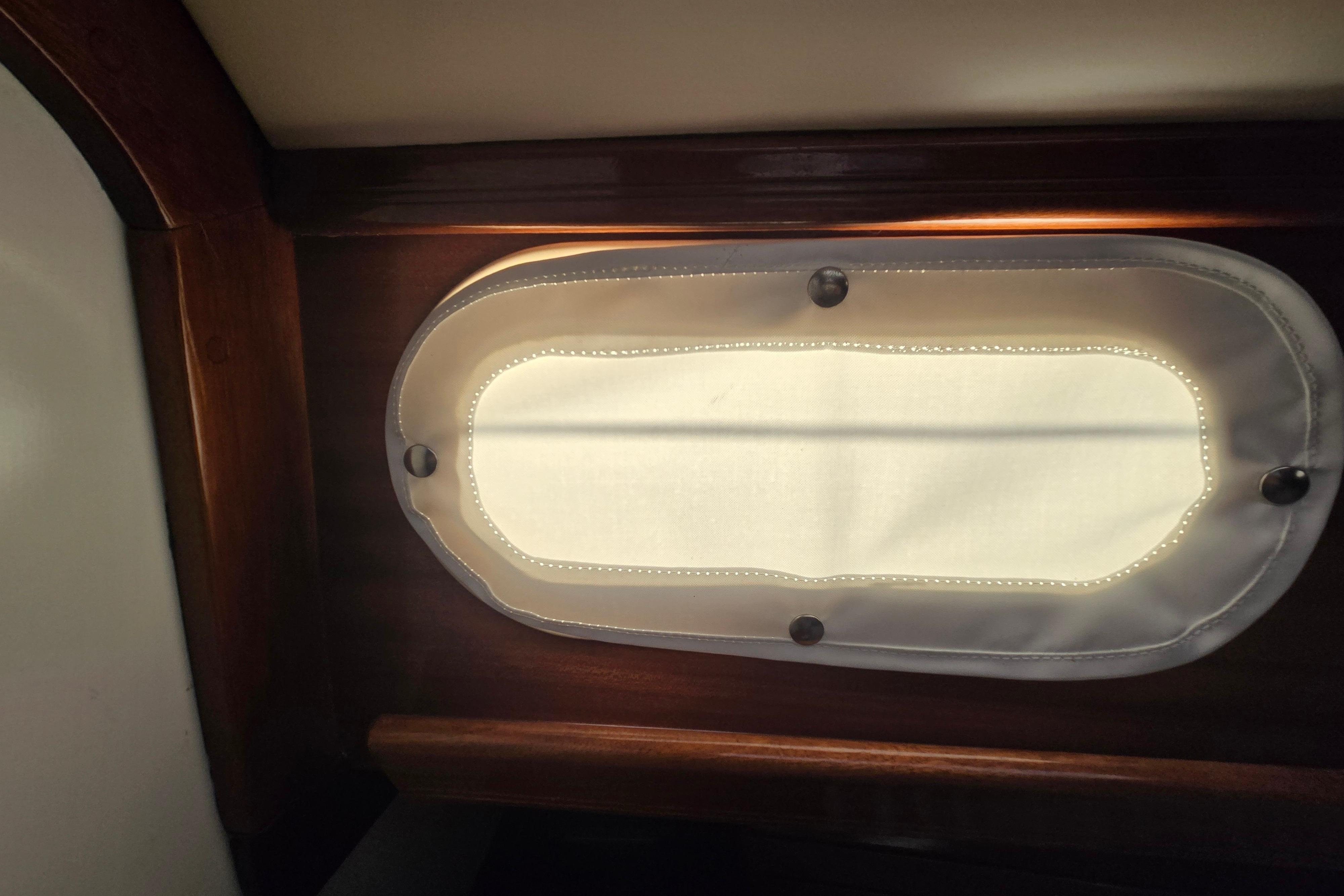 Interior view of a 1970 Hinckley Bermuda 40 sailboat porthole with wooden trim.