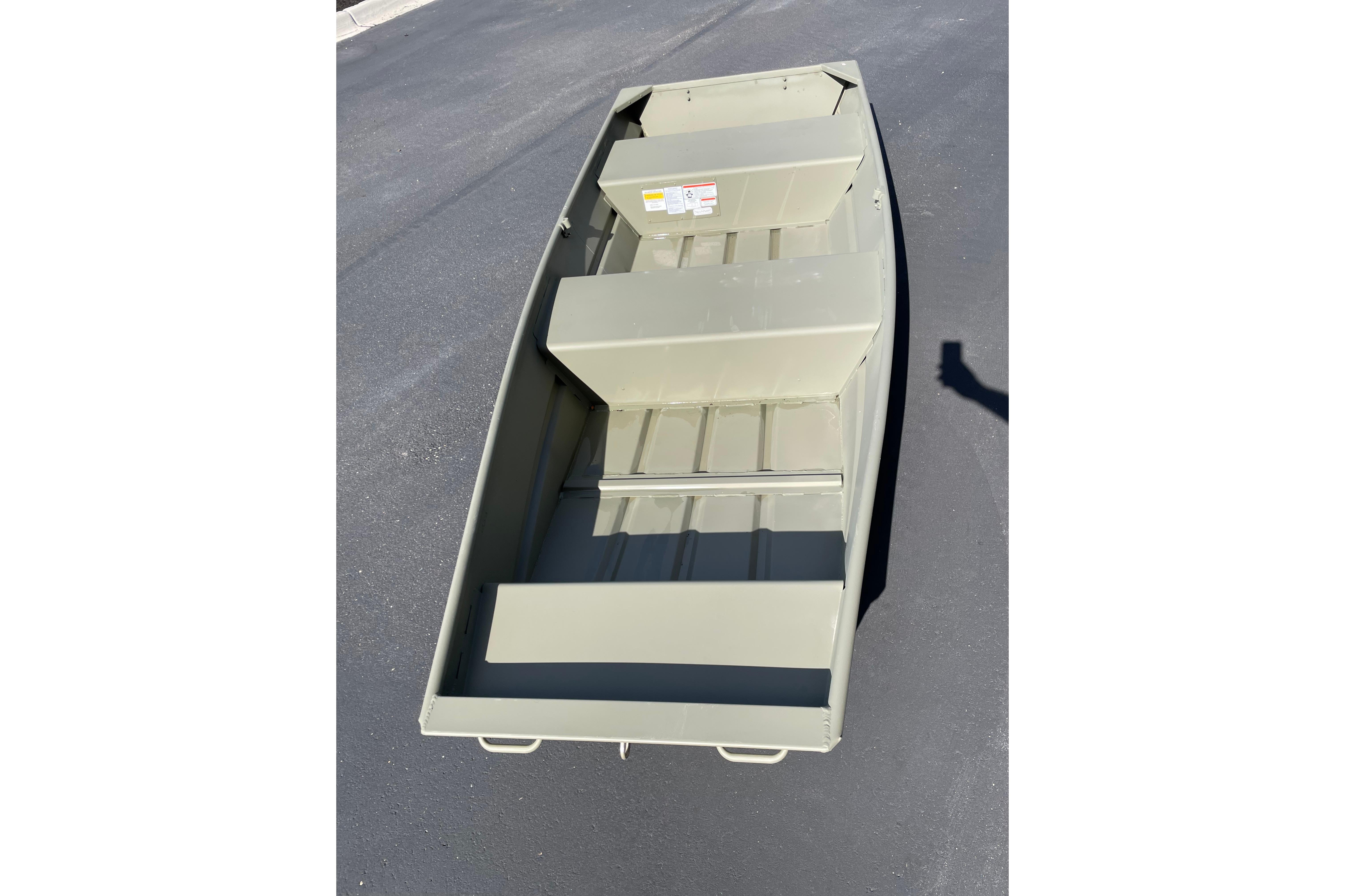 2026 Tracker Grizzly 12 Jon boat on pavement, showcasing interior seating and structure.