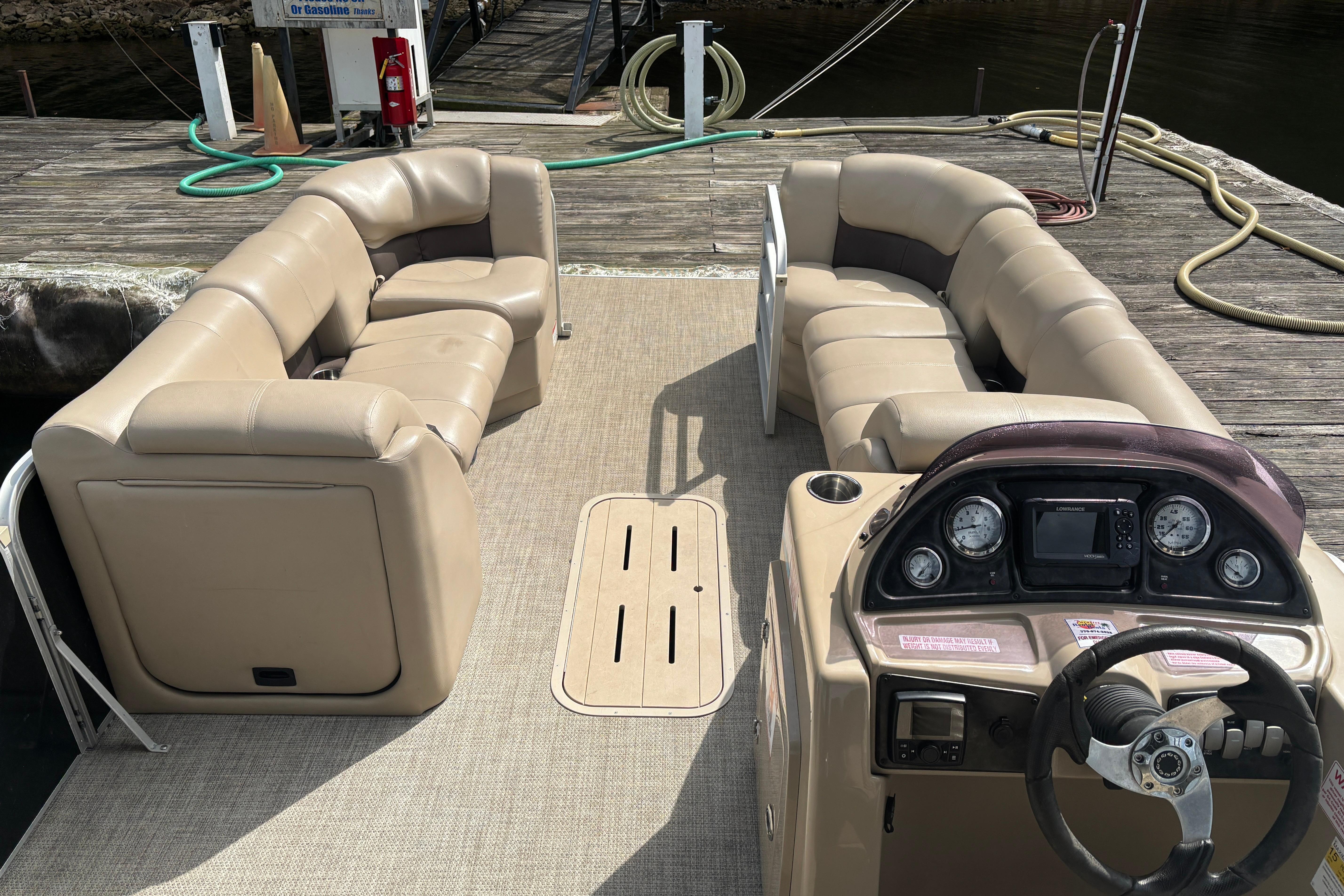 2021 SunCatcher Fusion 325RCX pontoon boat interior with beige seating and control panel.