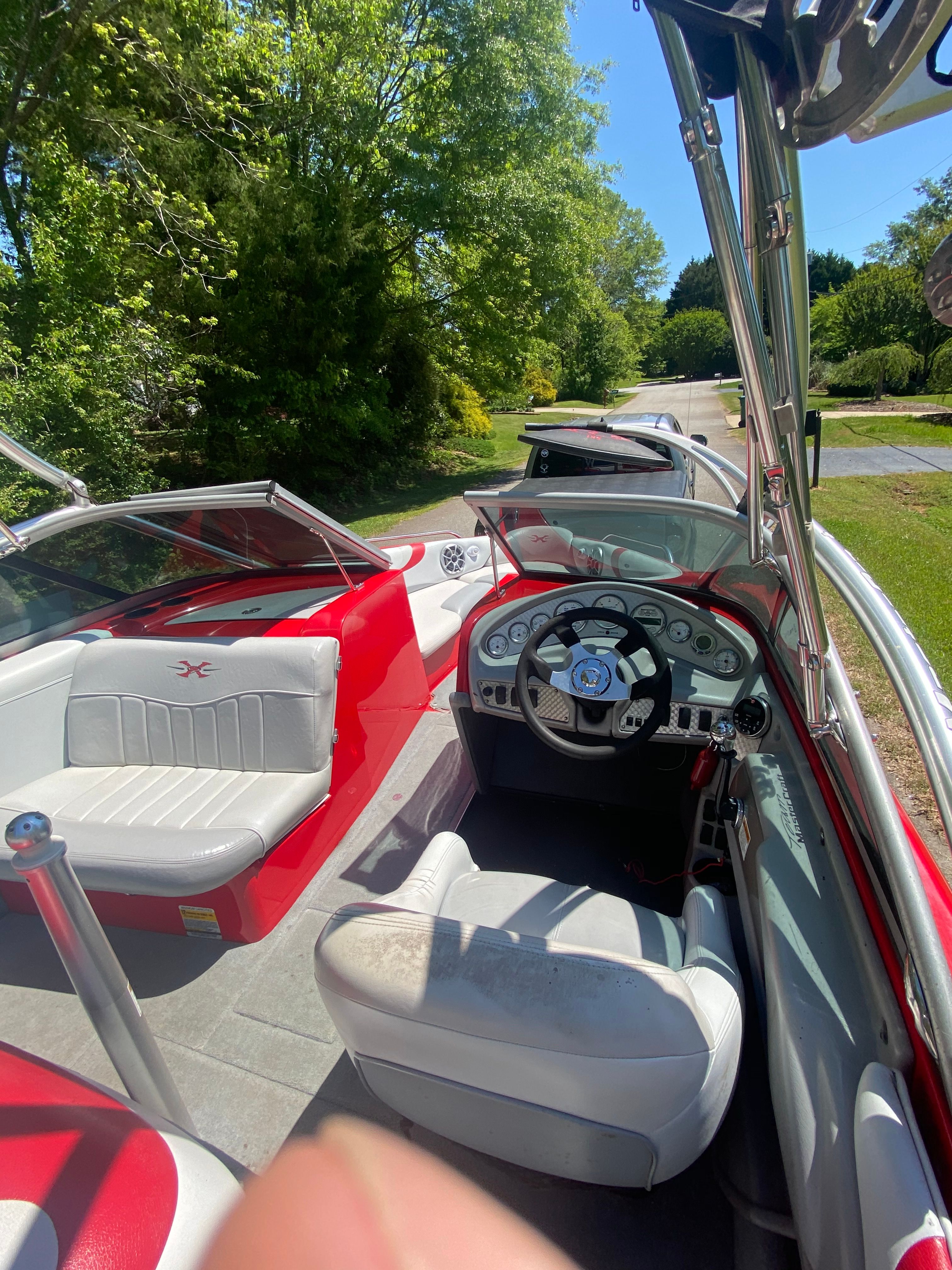 Interior view of a 2004 MasterCraft X-9 boat with white and red seating and a helm.