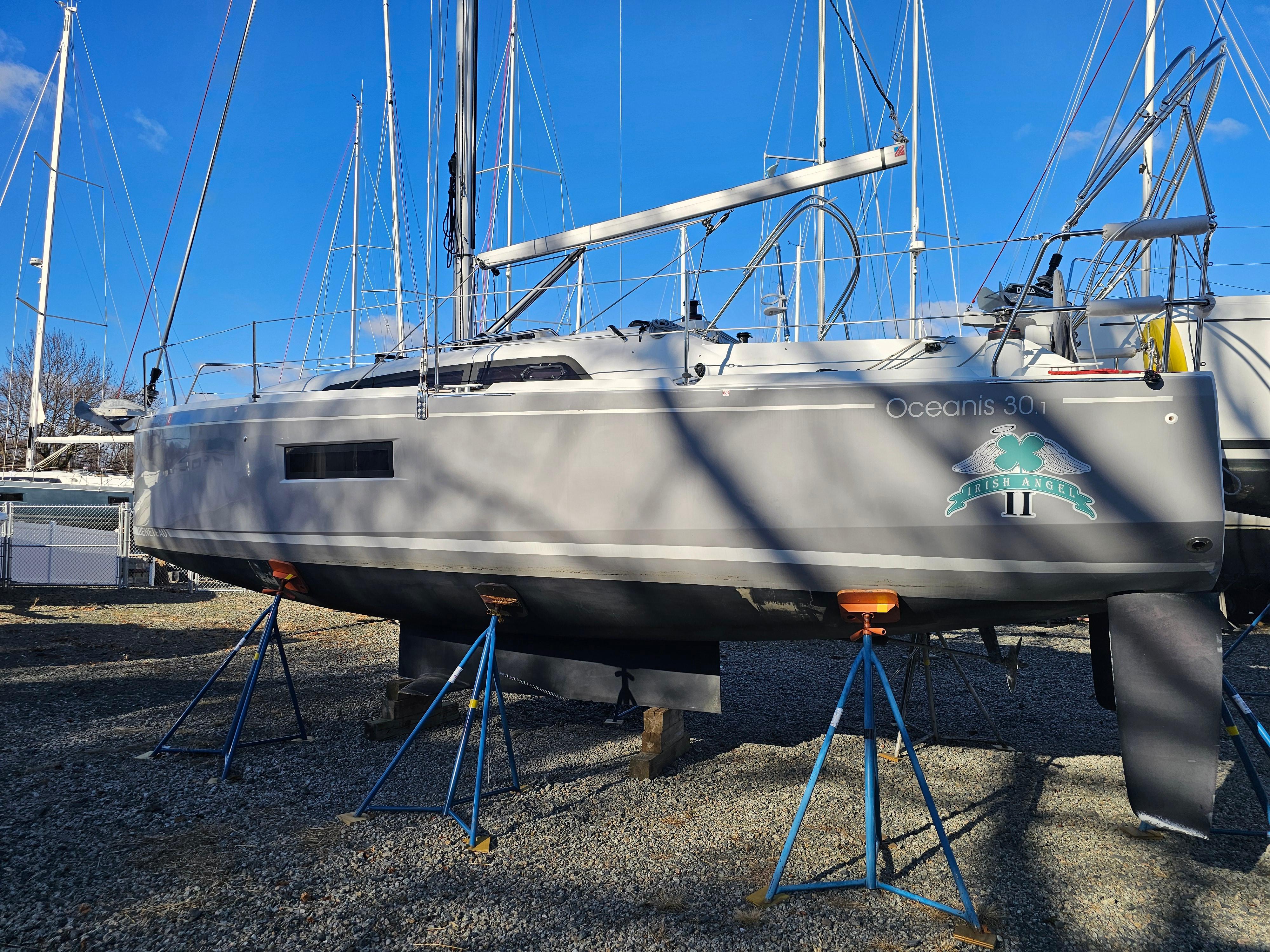 2022 Beneteau Oceanis 30.1 sailboat on stands, displayed outdoors under clear blue sky.