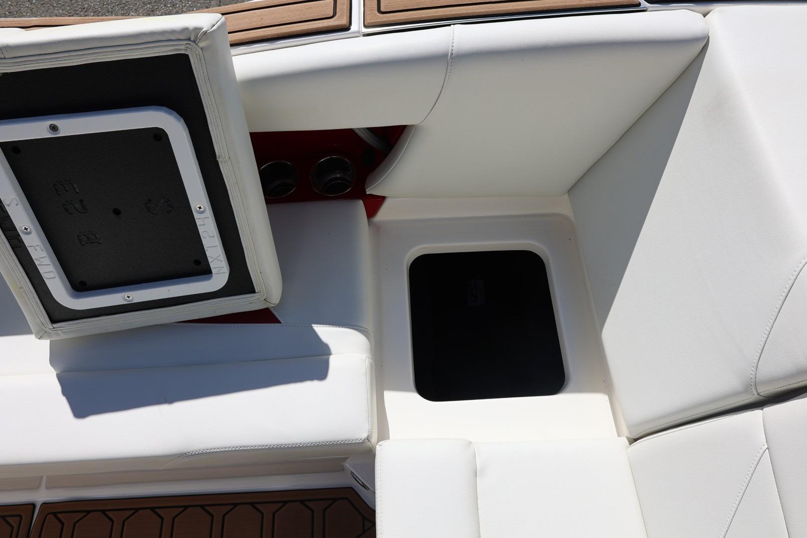 2021 MasterCraft NXT24 boat interior with open storage compartment and white seating.