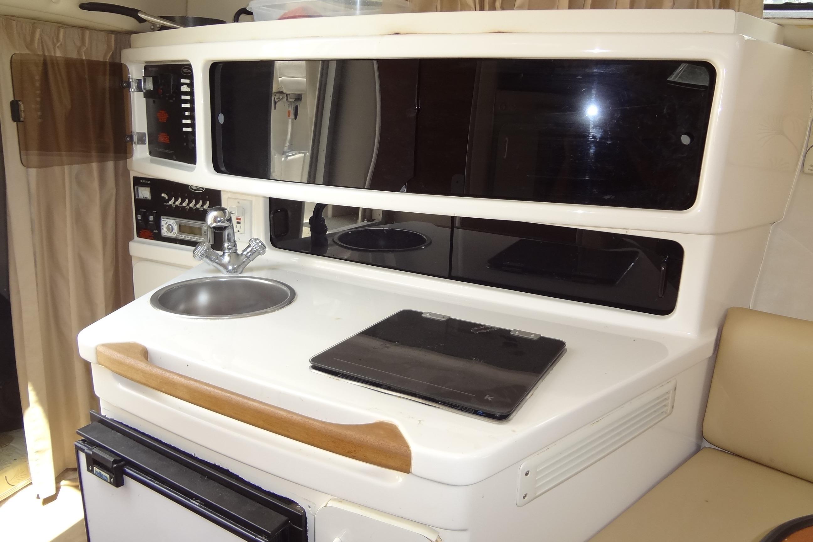 2000 Chaparral Signature 260 boat interior with kitchenette, sink, and storage cabinets.