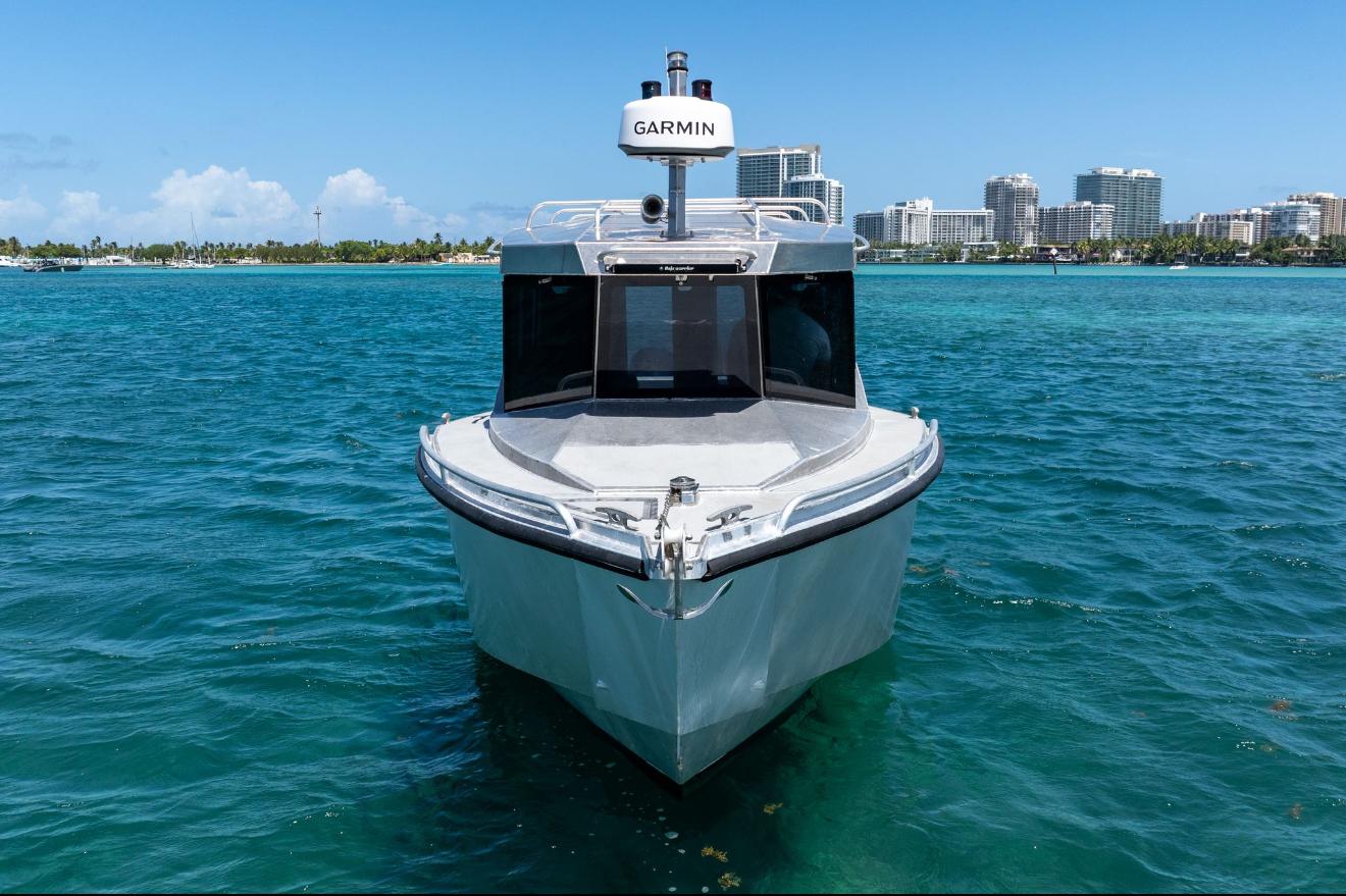 2026 Novielli Alaskan 296 boat on clear blue water with city skyline background.