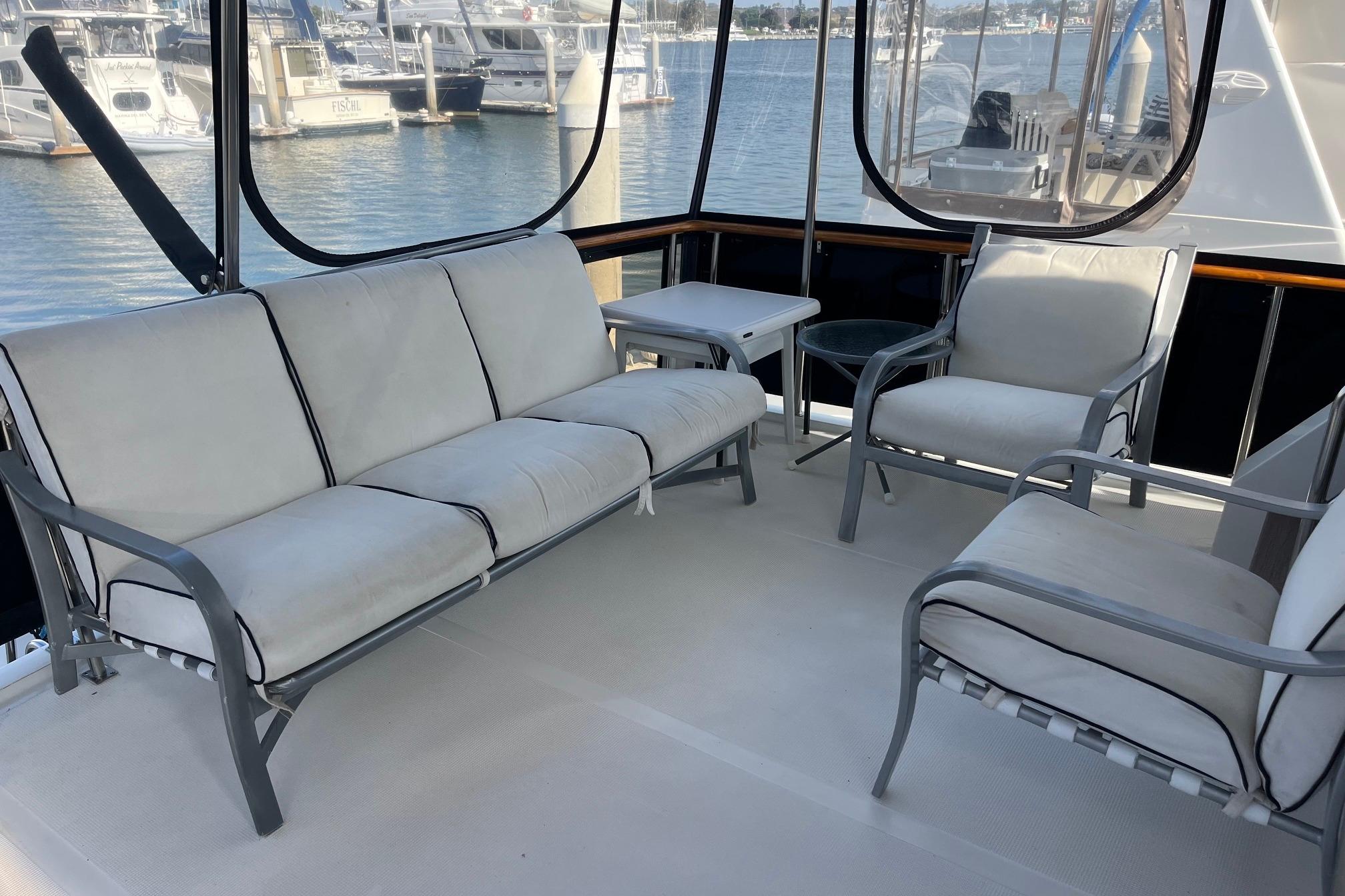 Spacious seating area on 1989 Ocean Alexander 440 Sundeck CPMY yacht, overlooking marina.
