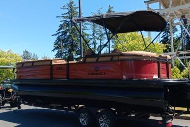 2026 Regency 250 DL pontoon boat with canopy, parked outdoors on a sunny day.