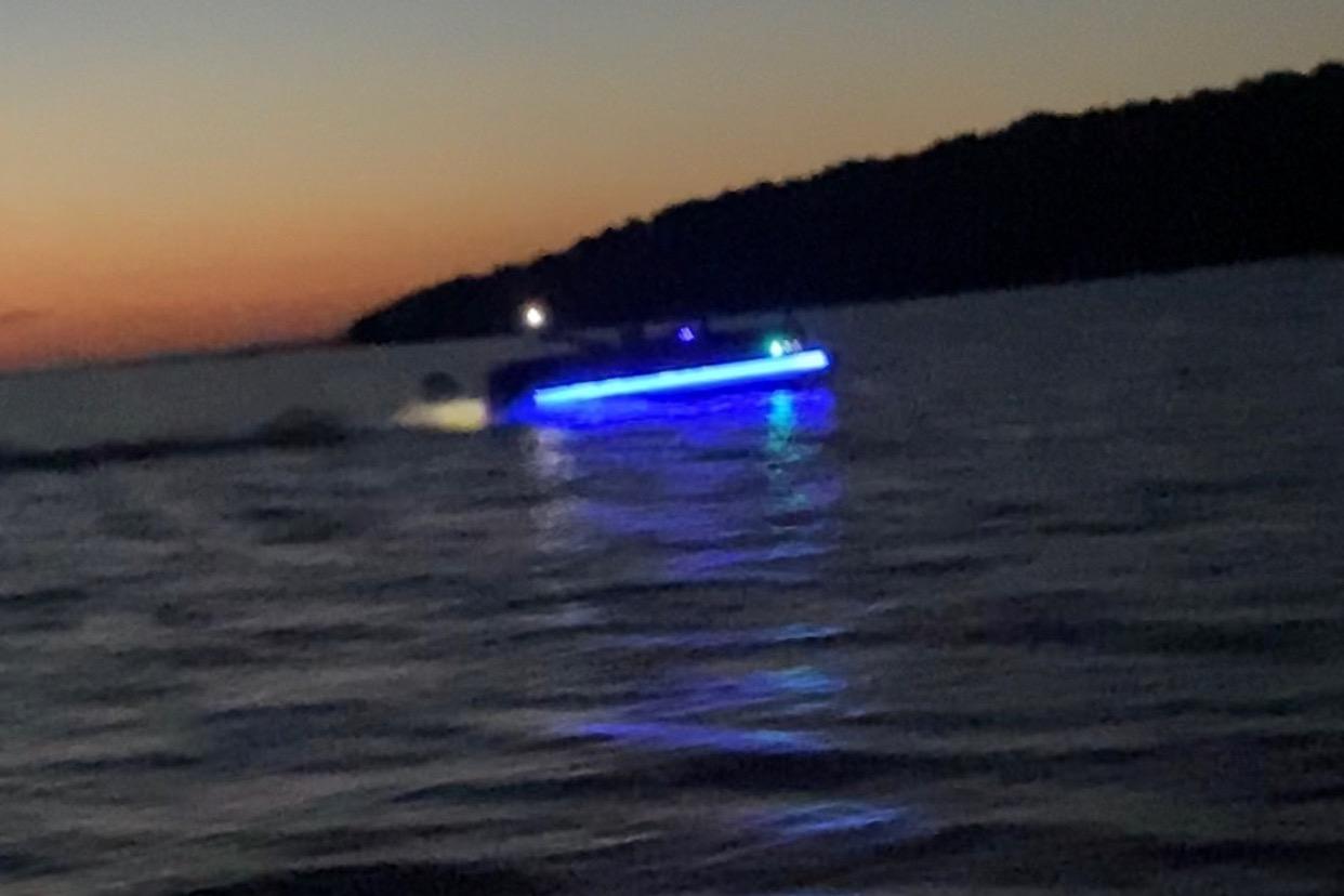 2022 Avalon Catalina 2785 boat with blue lights on water at sunset.