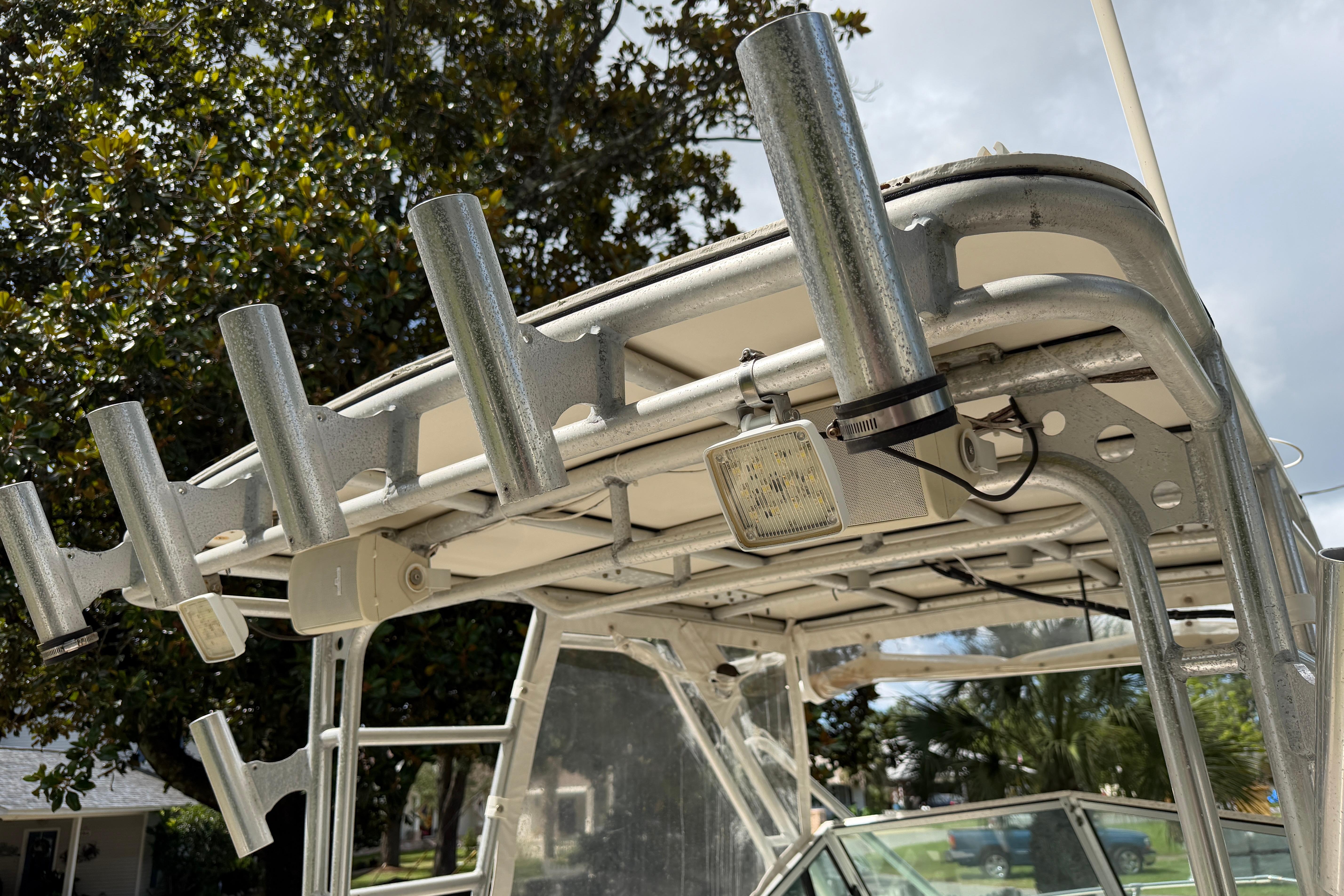 1987 Grady-White Seafarer 226 boat with rod holders and canopy, under a cloudy sky.