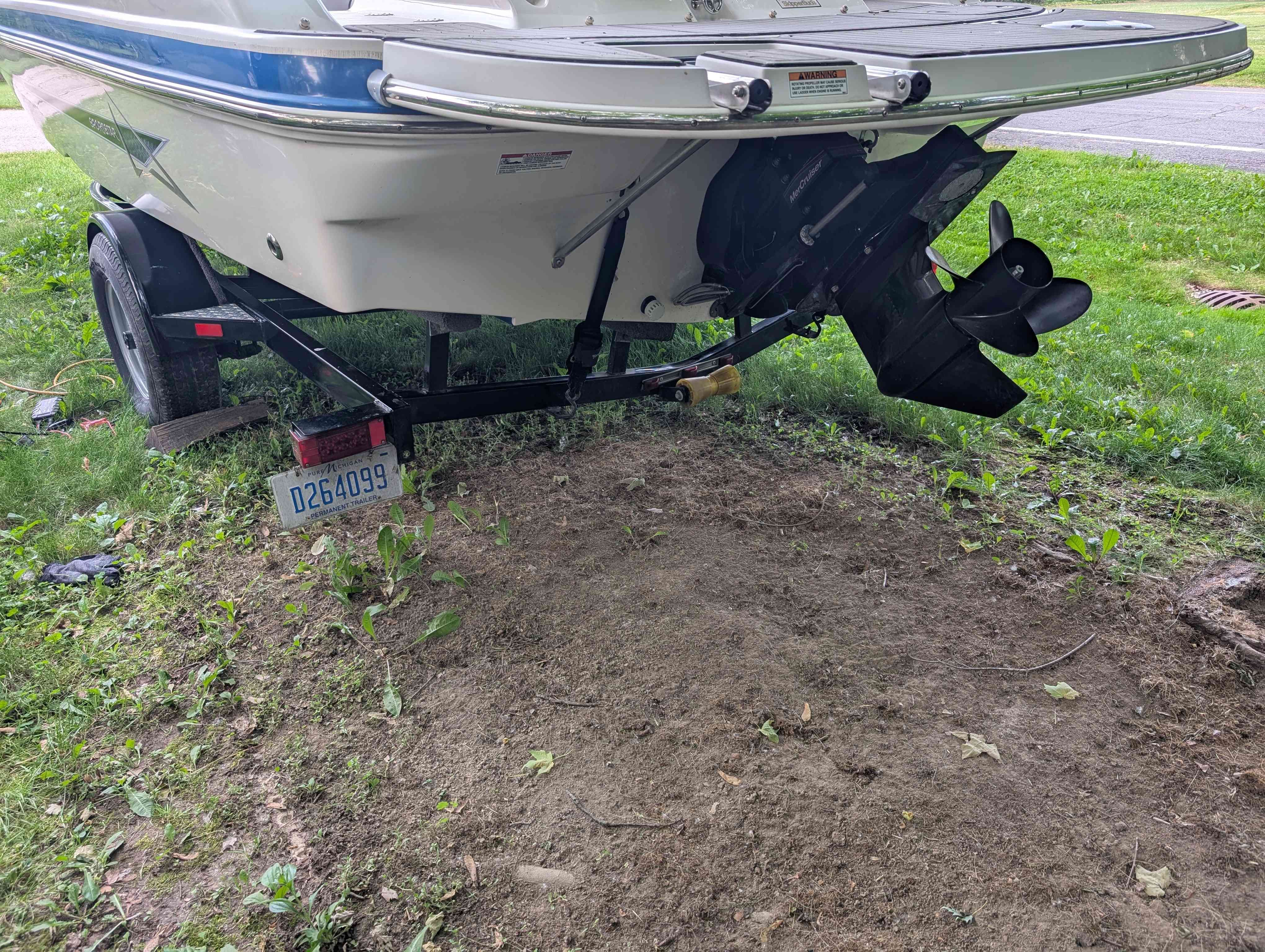 2015 Starcraft 2000 boat on trailer in grassy area.