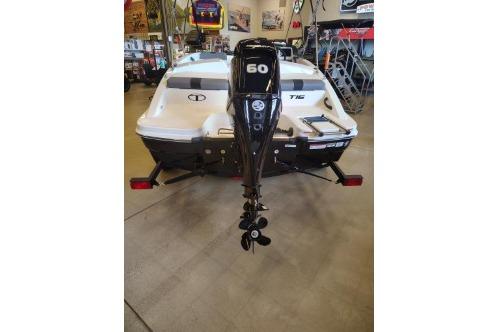 2026 Tahoe T16 boat with 60 HP outboard motor displayed indoors.