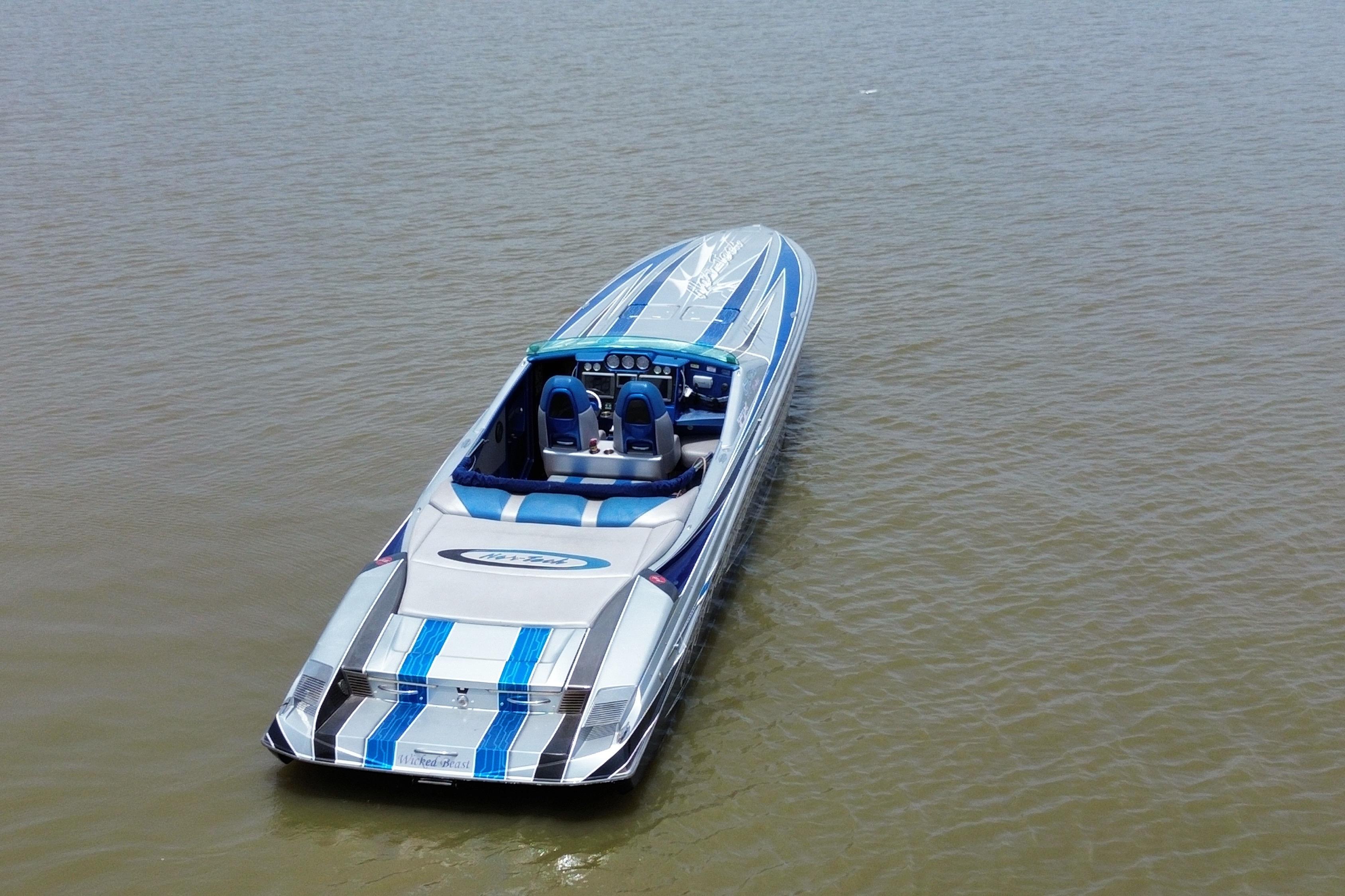 2013 Nor-Tech 477 SPX Vee Bottom boat on calm water, featuring sleek blue and silver design.
