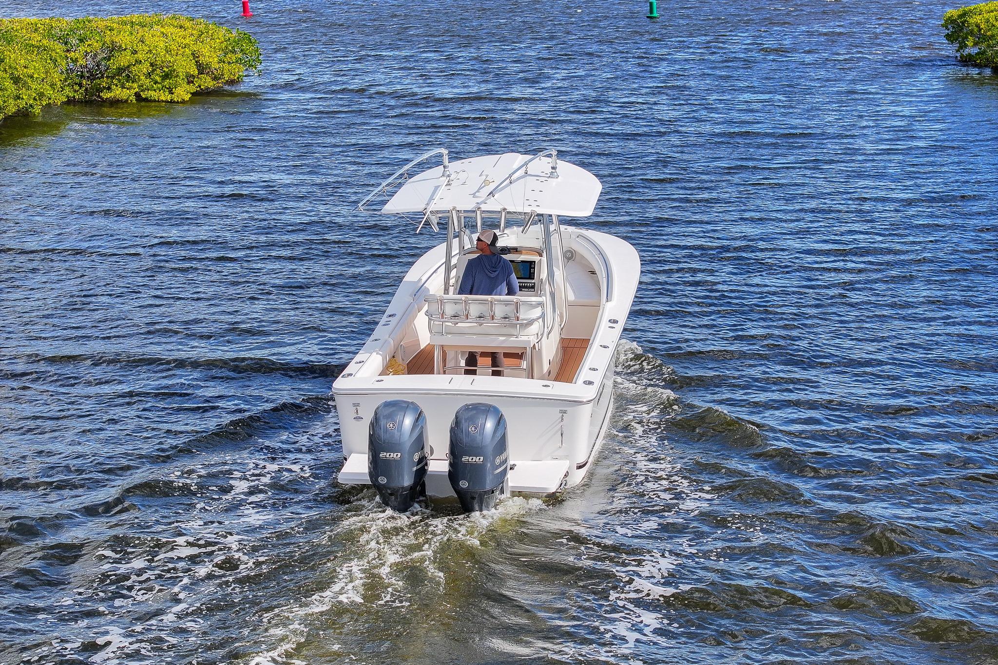2015 Regulator 25 boat cruising on open water with twin engines.
