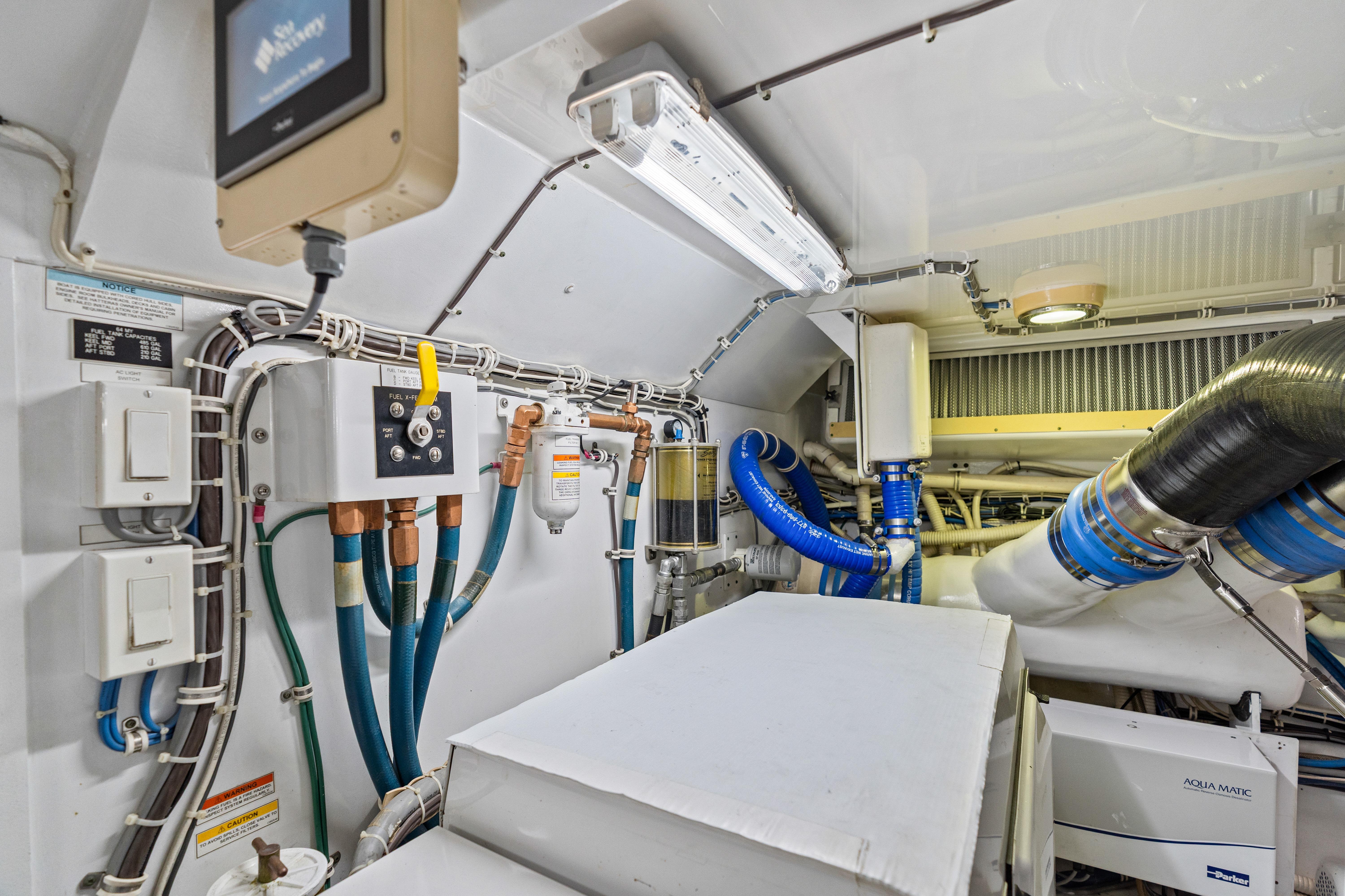 Engine room of 2008 Hatteras 64 Motor Yacht with visible wiring and equipment.