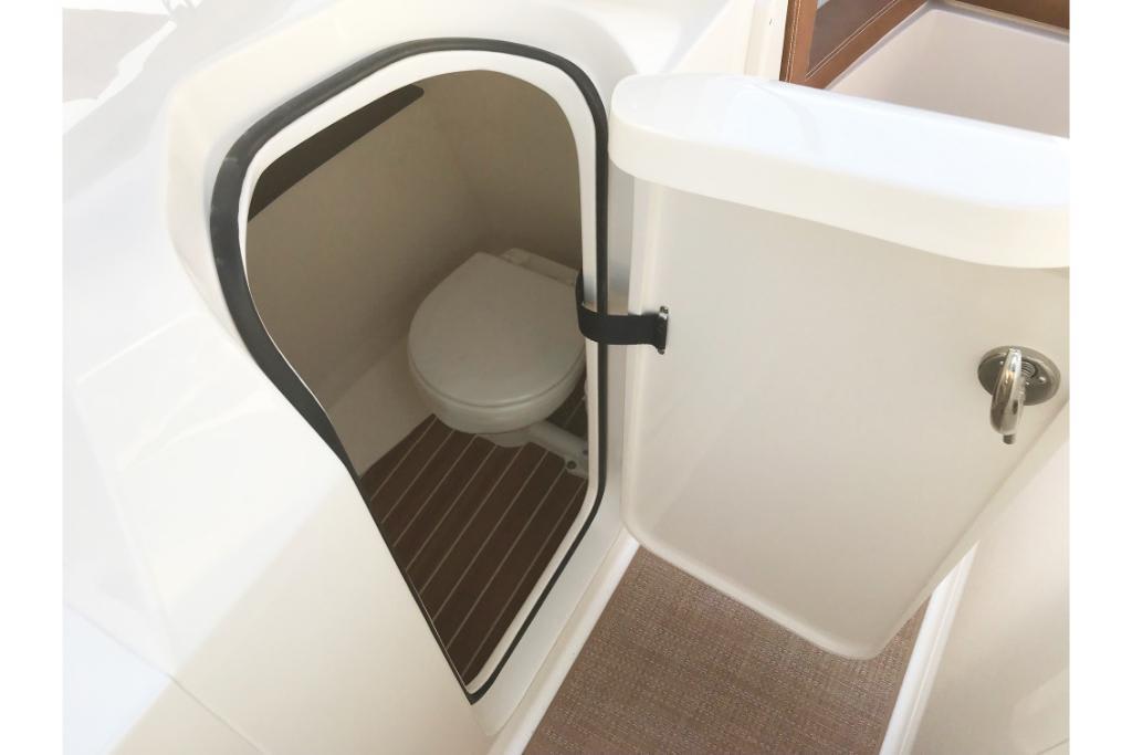 2023 Scout 240 Dorado boat interior with compact marine toilet.