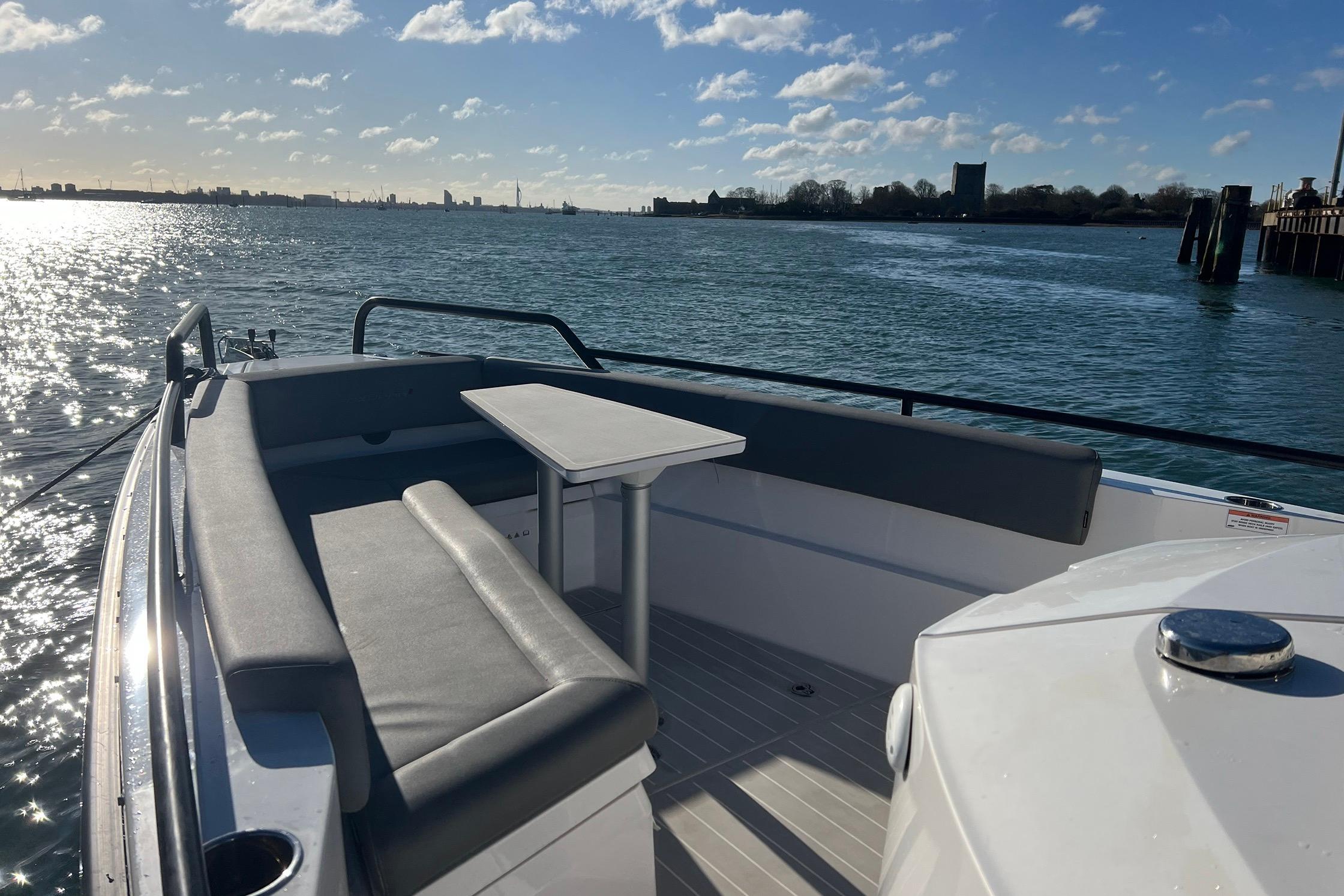 2019 Axopar 28 T-Top boat with seating area, table, and scenic water view.