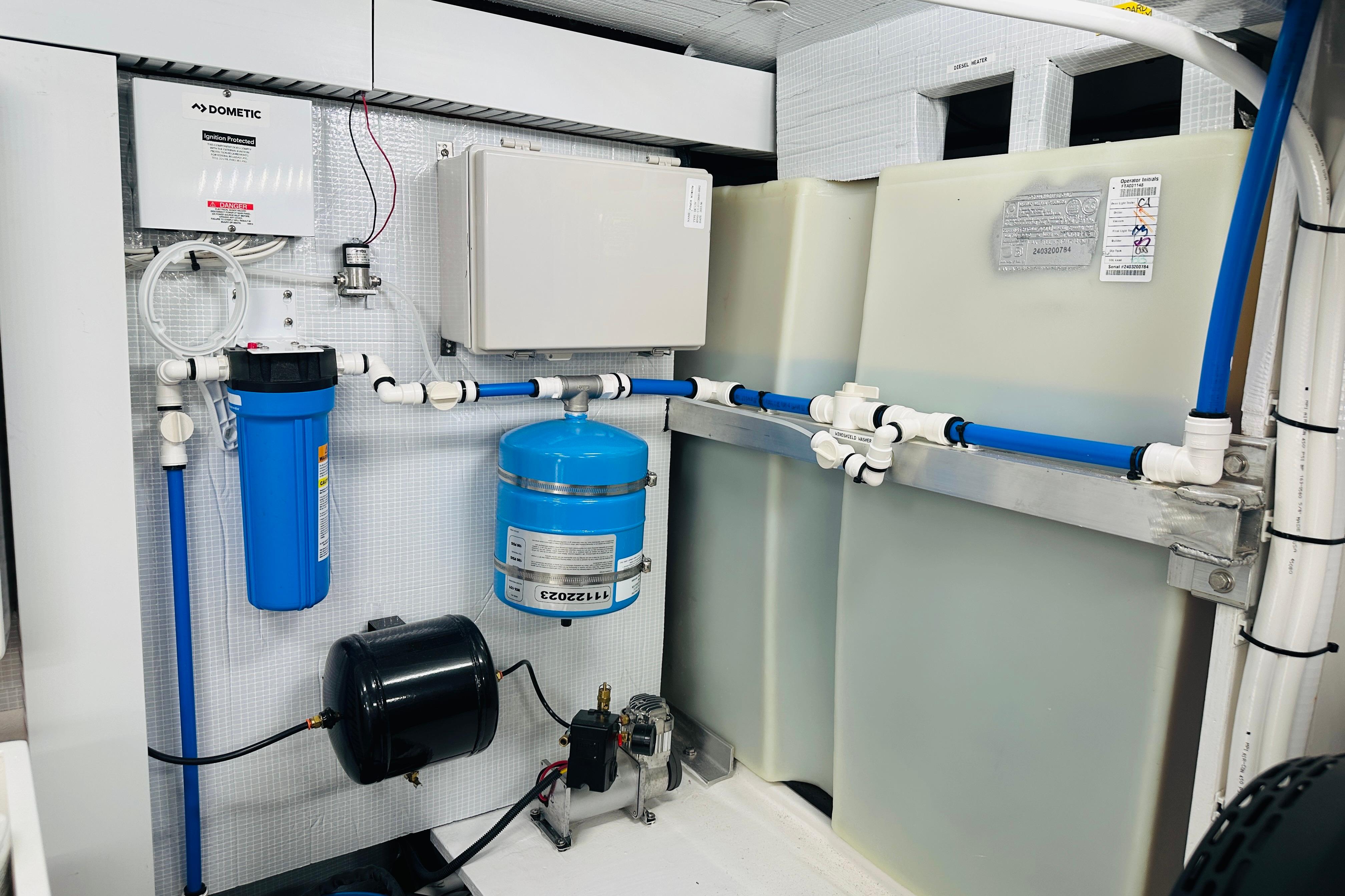 Engine room of 2025 Sabre 48 Salon Express, featuring water filtration and plumbing systems.