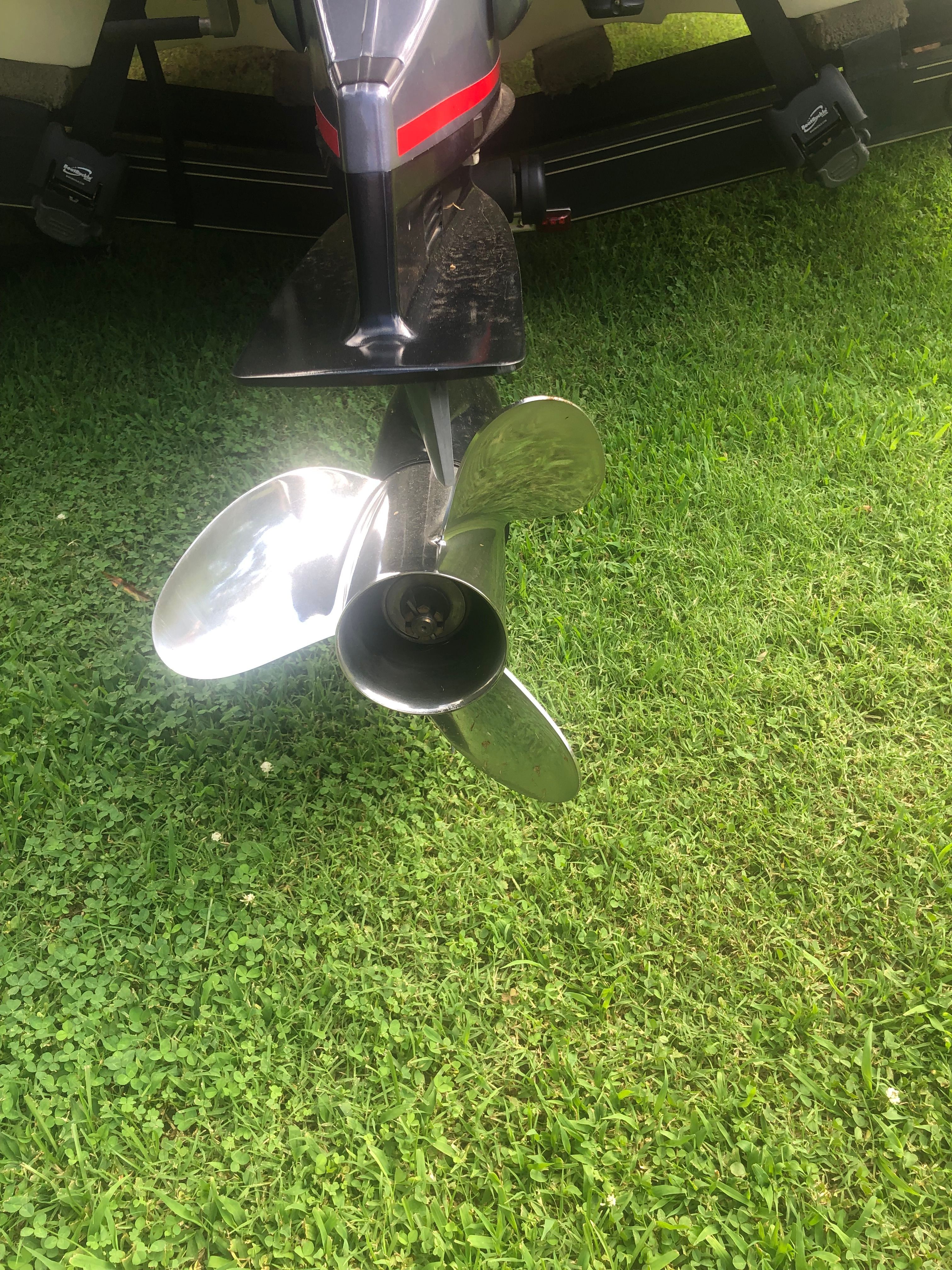 A shiny propeller of a 2012 Skeeter ZX190 boat on green grass.