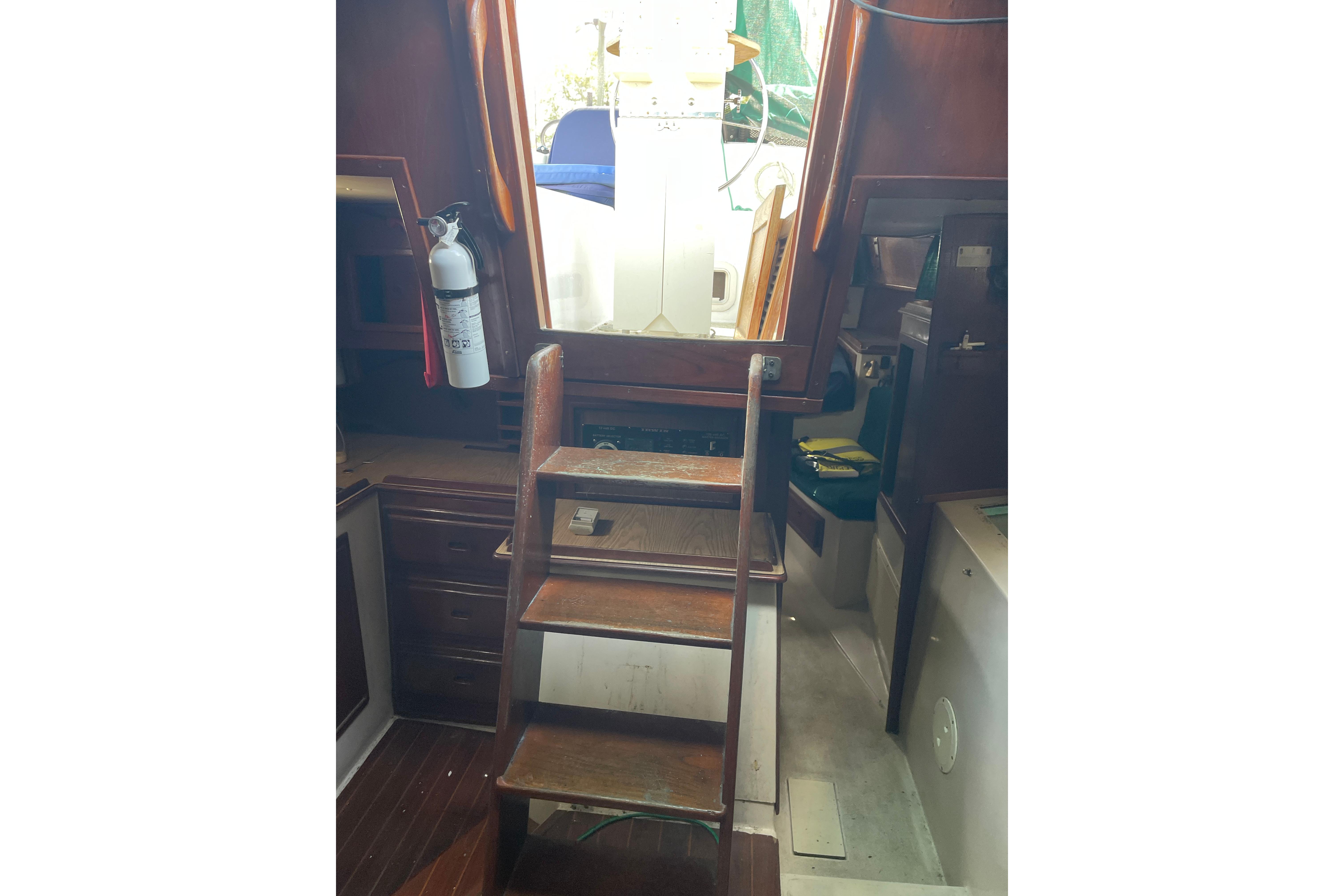 Interior view of Irwin 37 Mk V sailboat with wooden steps and fire extinguisher.